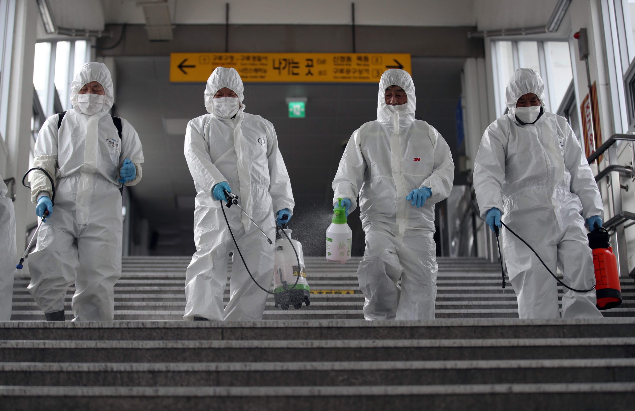 Workers wearing protective gear spray disinfectant to help prevent the spread of the COVID-19 coronavirus, at a subway station in Seoul on March 12, 2020. - South Korea reported fewer than 120 new coronavirus cases on March 12, but authorities warned that a new cluster in Seoul could see the infection spread in the capital. (Photo by - / YONHAP / AFP) / - South Korea OUT / REPUBLIC OF KOREA OUT  NO ARCHIVES  RESTRICTED TO SUBSCRIPTION USE