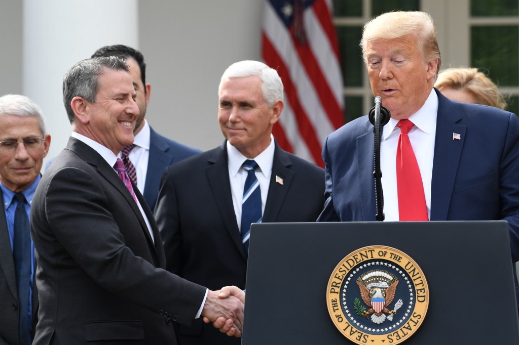 Brian Cornell, Chairman and CEO of Target Corporation shakes hands with US President Donald Trump at a press conference on COVID-19, known as the coronavirus, in the Rose Garden of the White House in Washington, DC, March 13, 2020. - US President Donald Trump declared the novel coronavirus, COVID-19, a national emergency on March 13, 2020. (Photo by SAUL LOEB / AFP)