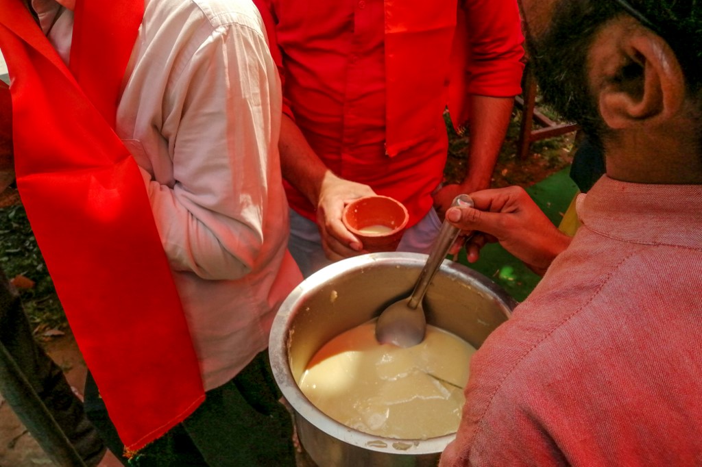 A man serves panchagavya, a traditional Hindu ritual mixture made of cow dung, urine, milk, curd and ghee, to members and supporters attending a 'gaumutra (cow urine) party' to fight against the spread of the COVID-19 coronavirus, organised by Hindu organisation 'Akhil Bharat Hindu Mahasabha' president Chakrapani Maharaj, in New Delhi on March 14, 2020. (Photo by Jalees ANDRABI / AFP)