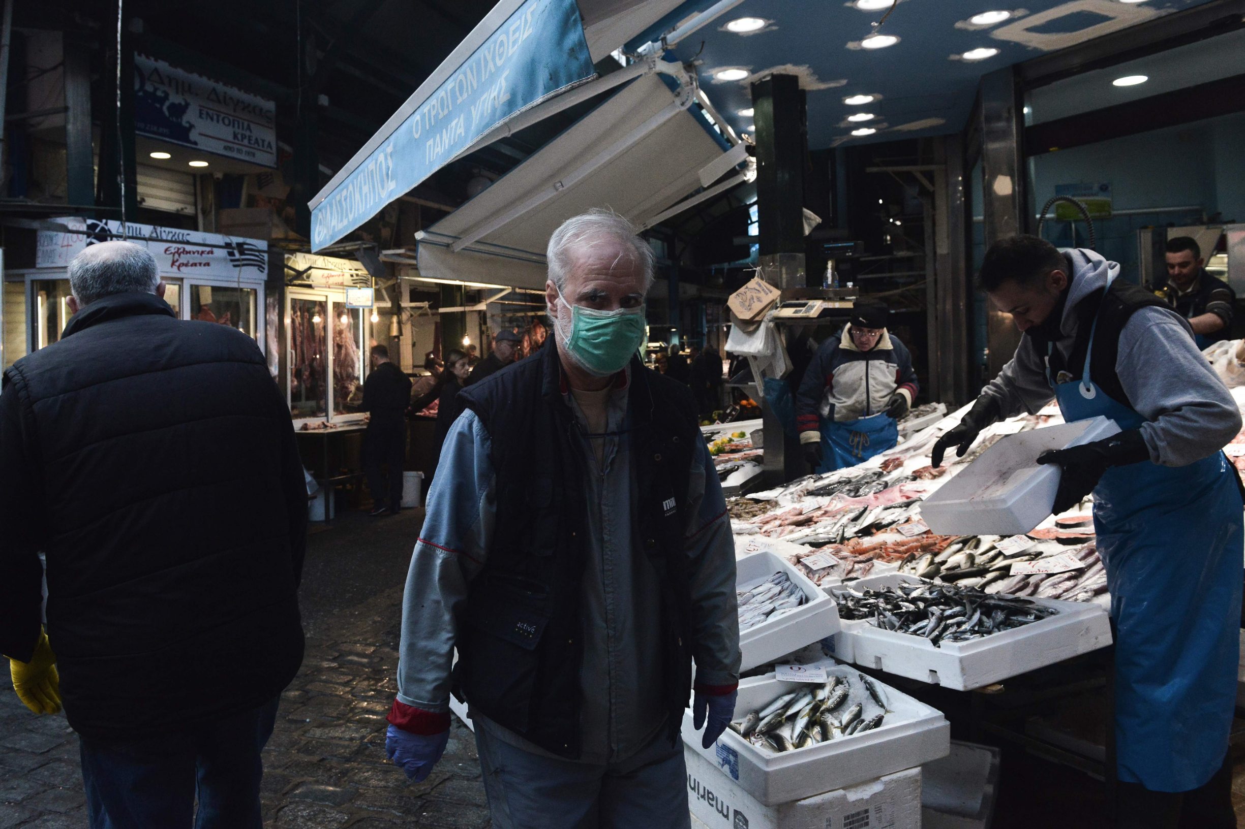 TOPSHOT - A man with a protective mask walks around the Kapani food market, in Thessaloniki on March 14, 2020, amid the measures taken to contain the spread of COVID-19 novel coronavirus. - Greece announced two more coronavirus deaths on March 14, 2020, bringing the toll to three, as an unprecedented lockdown takes effect. (Photo by Sakis MITROLIDIS / AFP)