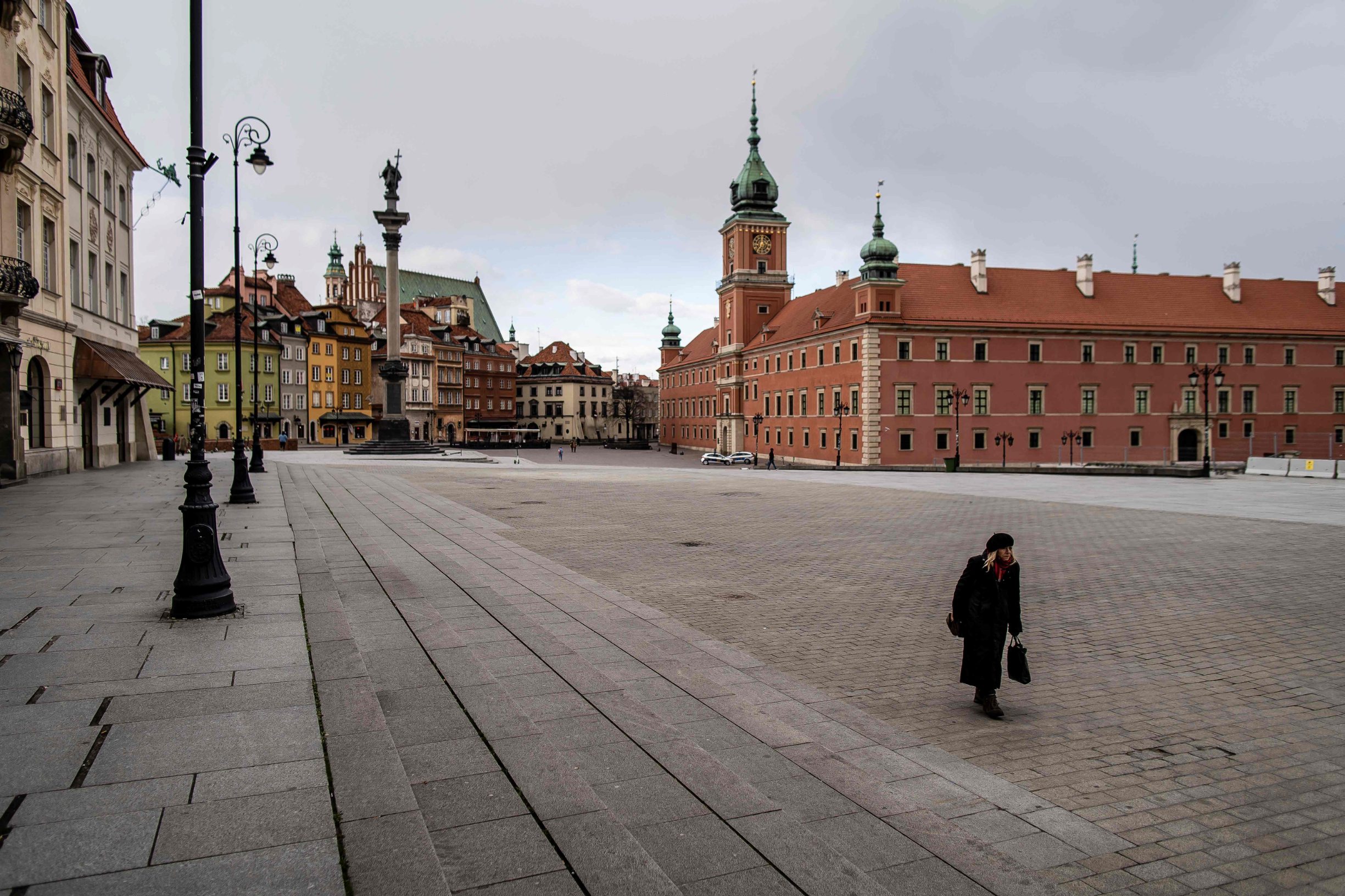 A woman walks on an empty square in the center of Warsaw, on March 14, 2020. - Polish government urged citizens to stay at home for a few weeks to limit the spread of the novel coronavirus. (Photo by Wojtek RADWANSKI / AFP)