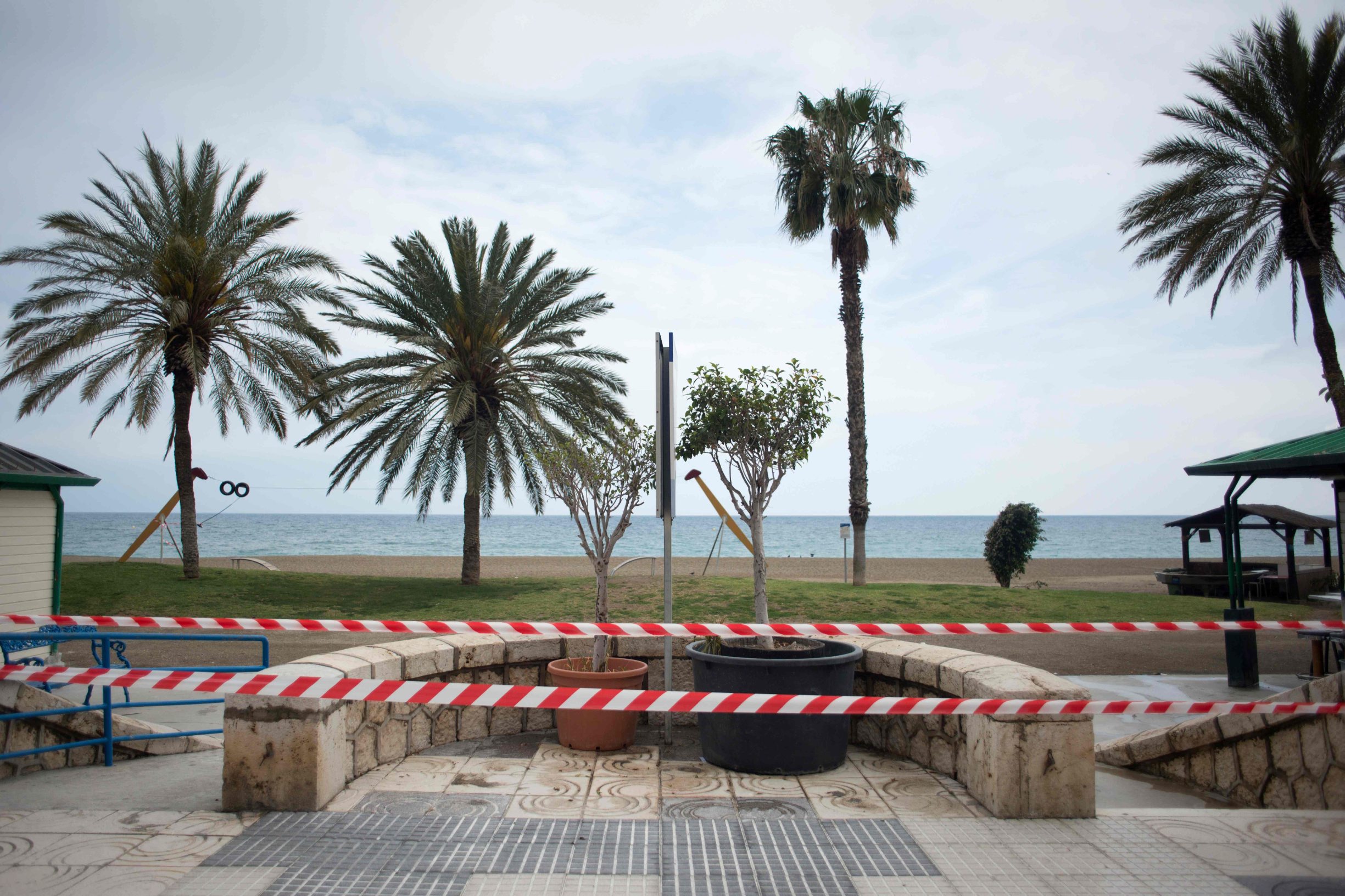 The Malagueta beach is cordoned off in Malaga on March 15, 2020. - France and Spain are the latest European nations to severely curtail people's movements as countries across the Americas and Asia impose travel restrictions in a widening crisis over coronavirus, as the number of infections around the world passed 150,000, with nearly 6,000 deaths. (Photo by JORGE GUERRERO / AFP)