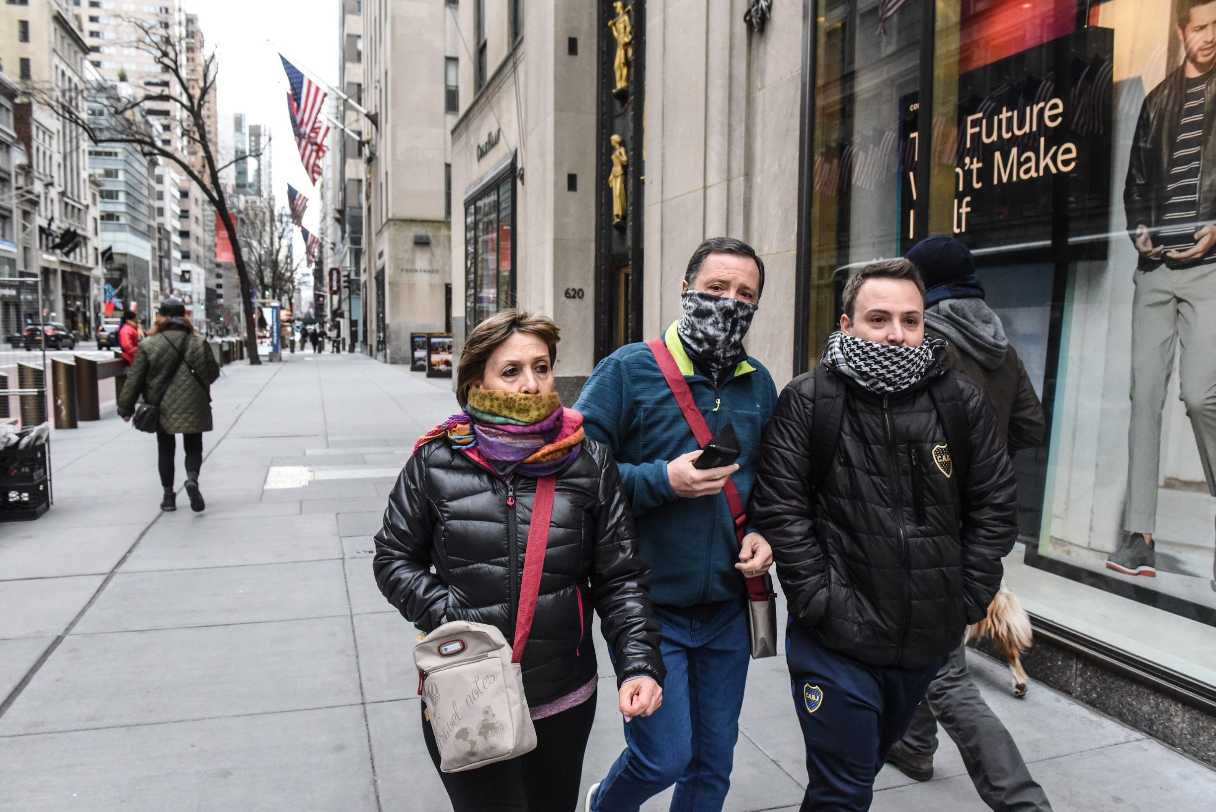 NEW YORK, NY - MARCH 15 : People wearing scarves over their faces walk down Fifth Avenue on March 15, 2020 in New York City. The World Health Organization declared COVID-19 a global pandemic on March 11.   Stephanie Keith/Getty Images/AFP
== FOR NEWSPAPERS, INTERNET, TELCOS & TELEVISION USE ONLY ==