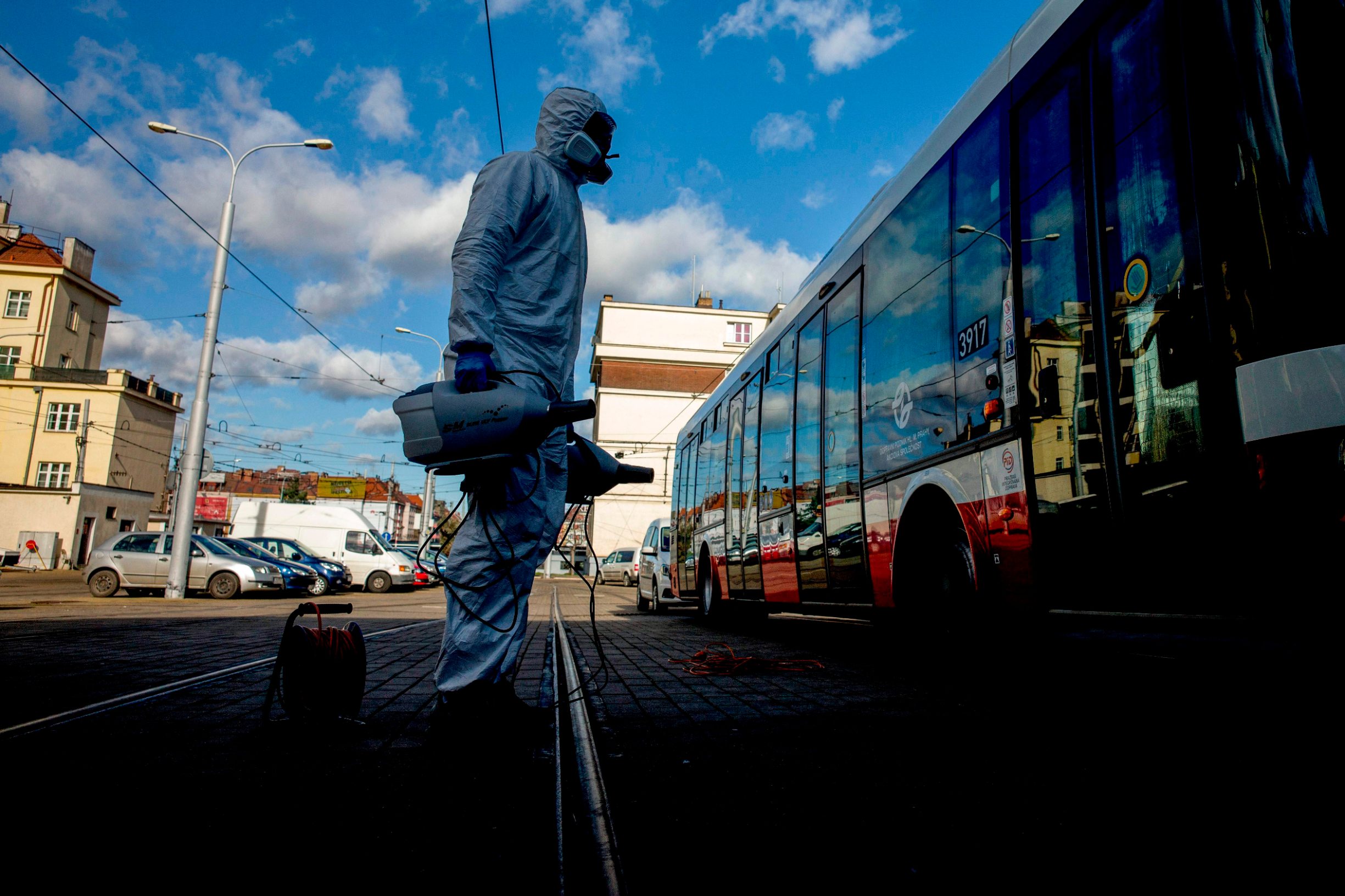 A worker stands next to a bus before testing a new nano polymer disinfection as part of precautionary measures against the spread of the new coronavirus COVID-19 on March 12, 2020 in Prague. - Czech Ministry of Health confirmed  94 cases of Covid -19 on March 11, 2020 in the Czech Republic . (Photo by Michal Cizek / AFP)