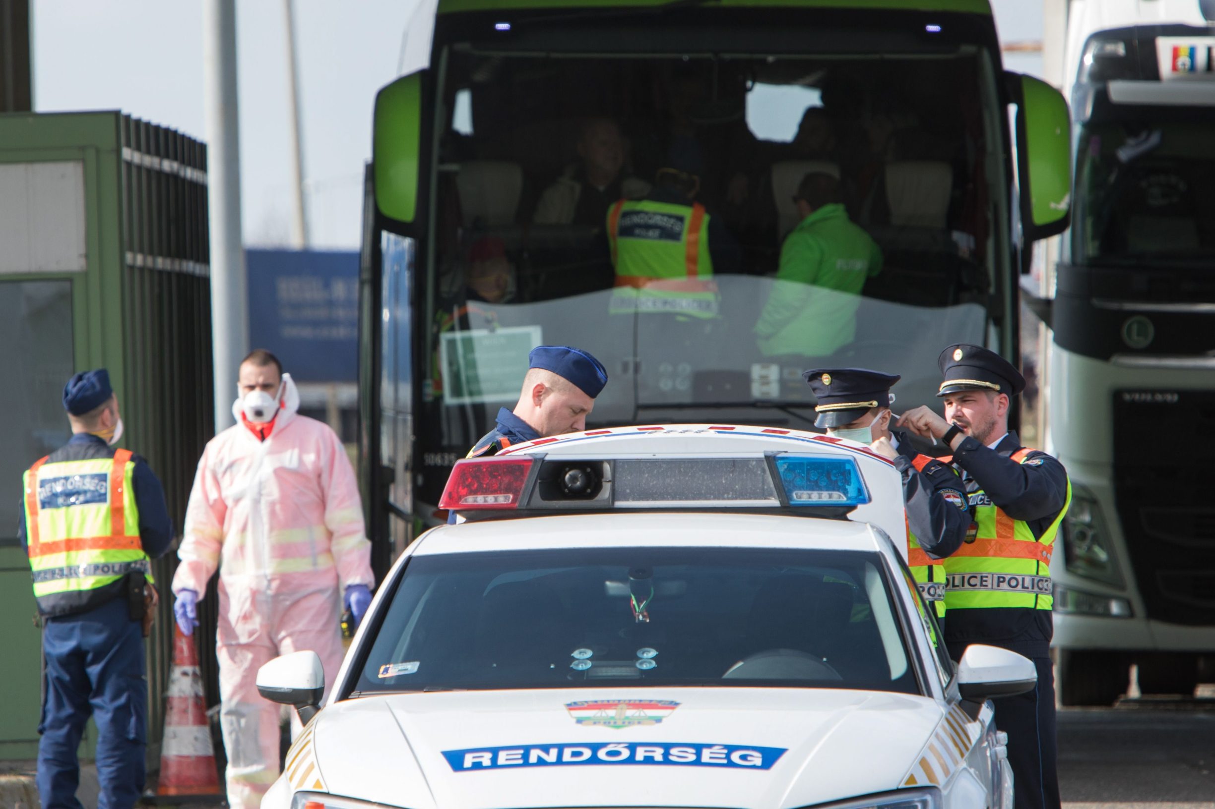 Hungarian police stand next to their car at the Nickelsdorf/Hegyeshalom border crossing between Austria and Hungary on March 14, 2020 as border controls have been implemented to limit the spread of the novel coronavirus. - So far, Hungary has confirmed 19 cases of infections, nine of them Iranians (mostly university scholarship-holders), one British national, and the rest Hungarians. (Photo by ALEX HALADA / AFP)