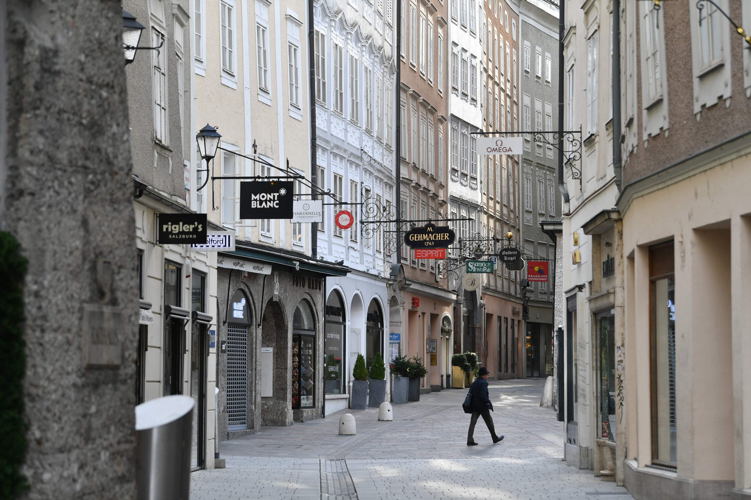 A man walks on March 17, 2020 through the Getreidegasse street in the historical centre of Salzburg, Austria, where touristic activities came to a halt due to the spread of the novel coronavirus. (Photo by BARBARA GINDL / APA / AFP) / Austria OUT