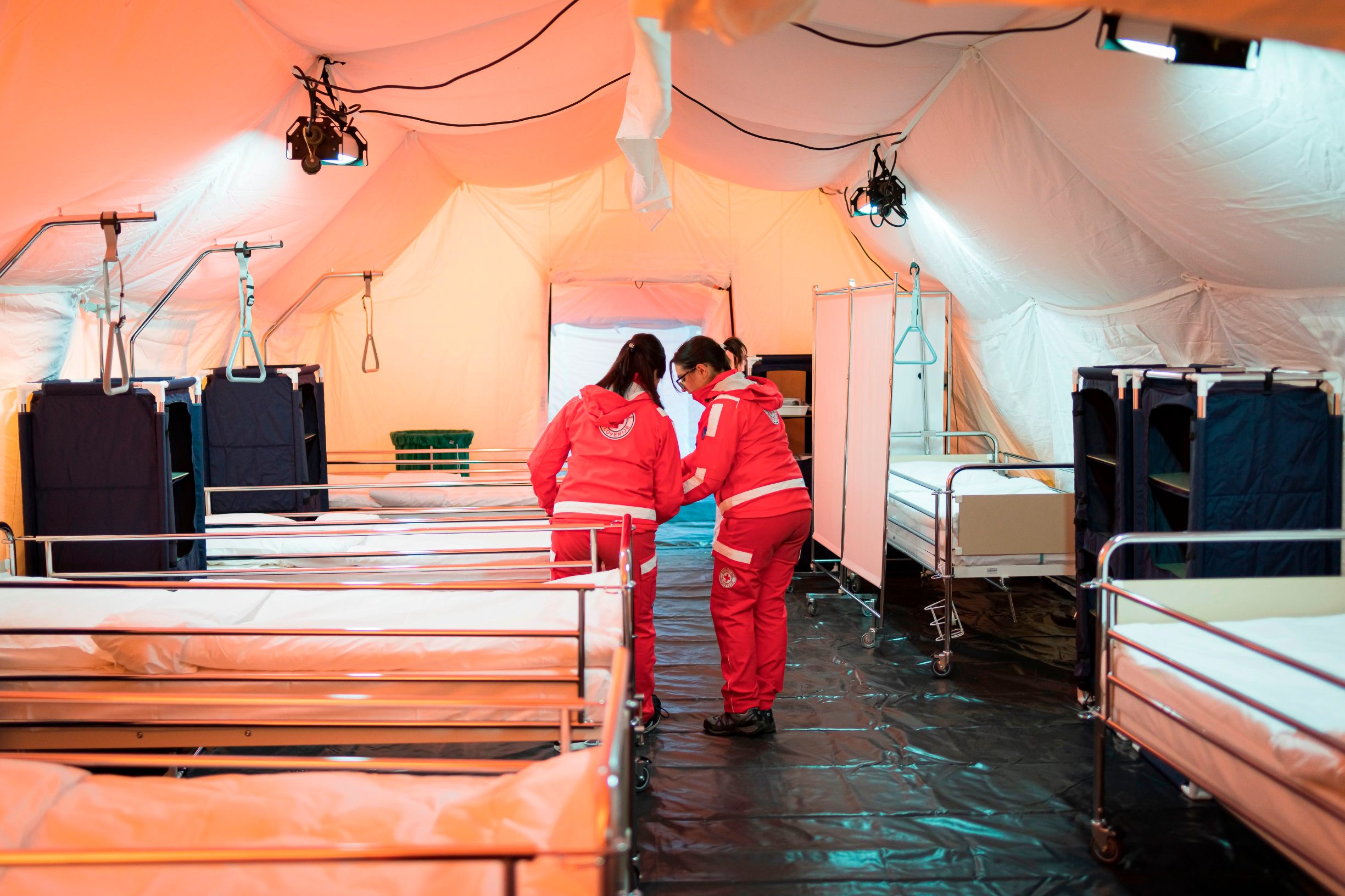 Members of Red Cross prepare beds at facilities for the treatment of coronavirus patients set at the Edvard Peperko Army Barracks in Ljubljana on March 17, 2020. (Photo by Jure Makovec / AFP)