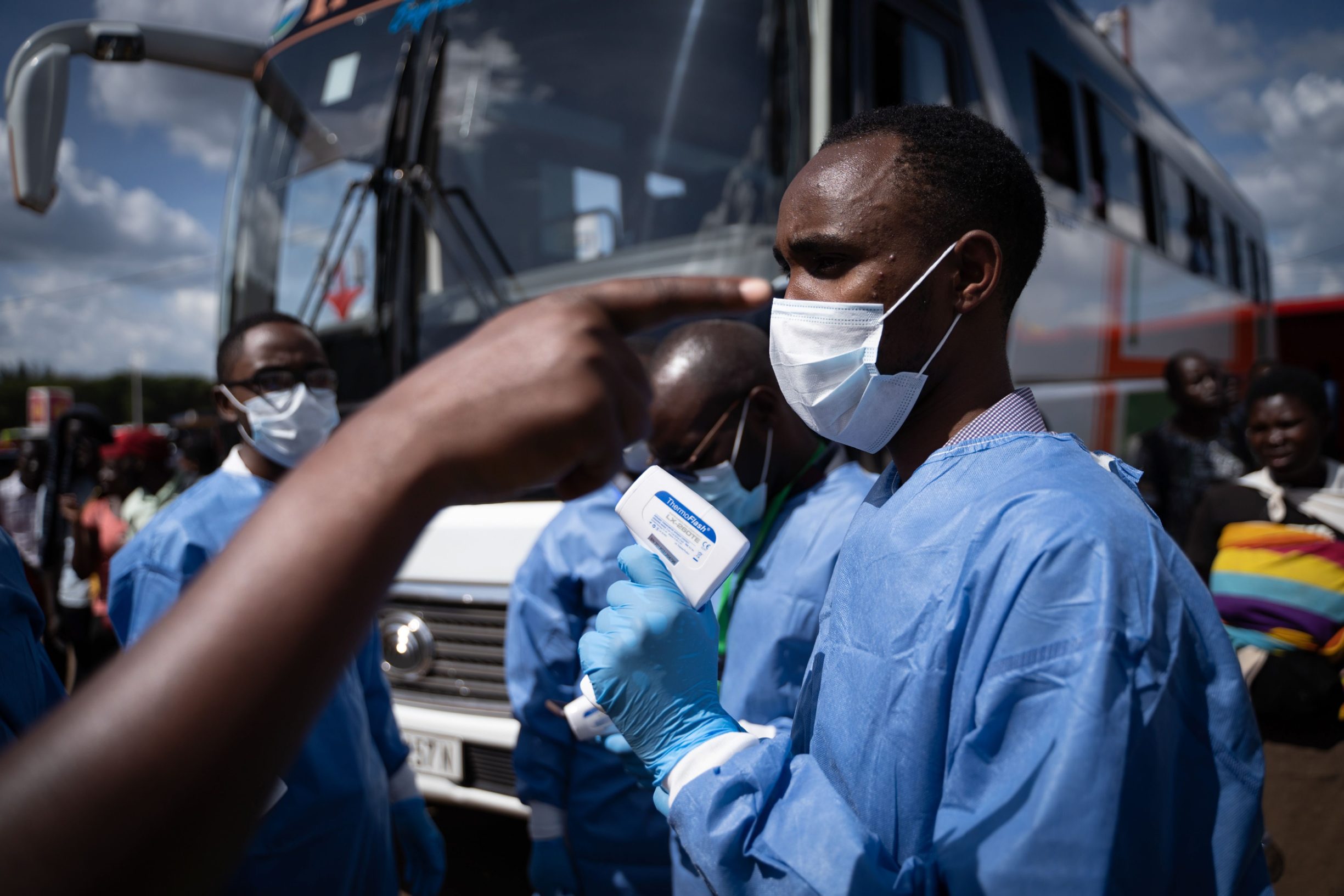 A staff of the Rwanda Biomedical Center (RBC) screens passengers at a bus station after the government suspended all unnecessary movements for two weeks to curb the spread of COVID-19 Coronavirus in Kigali, Rwanda, on March 22, 2020. - African countries have been among the last to be hit by the global COVID-19 coronavirus epidemic but as cases rise, many nations are now taking strict measures to block the deadly illness. (Photo by Simon Wohlfahrt / AFP)