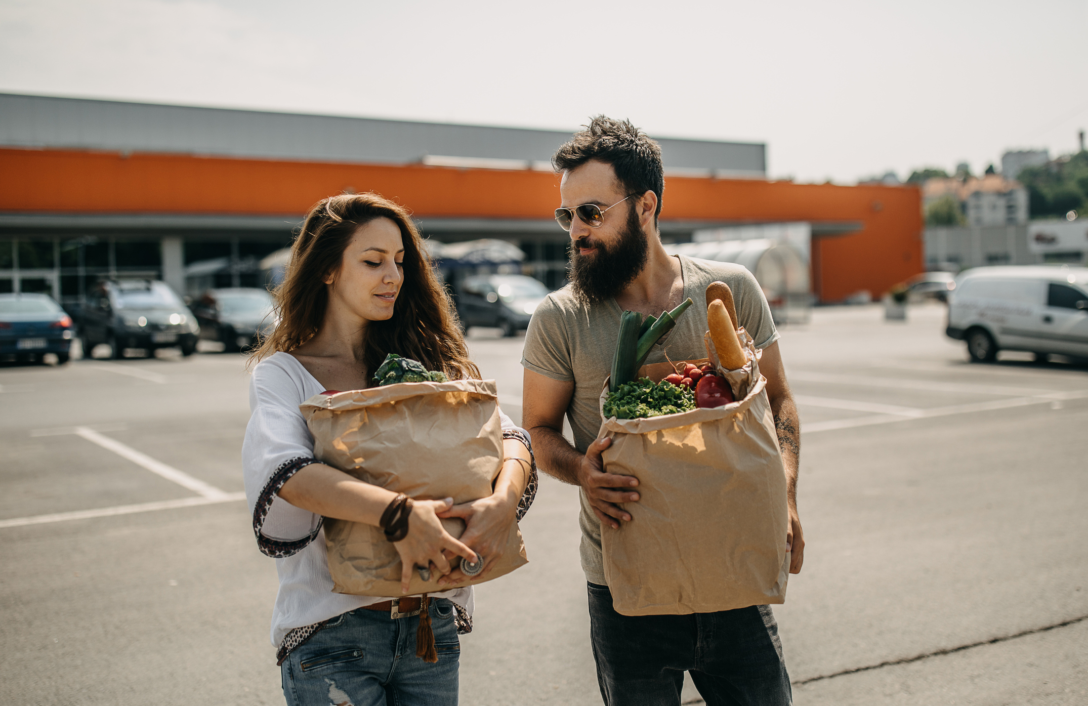 Young couple carrying a paper bag with groceries
