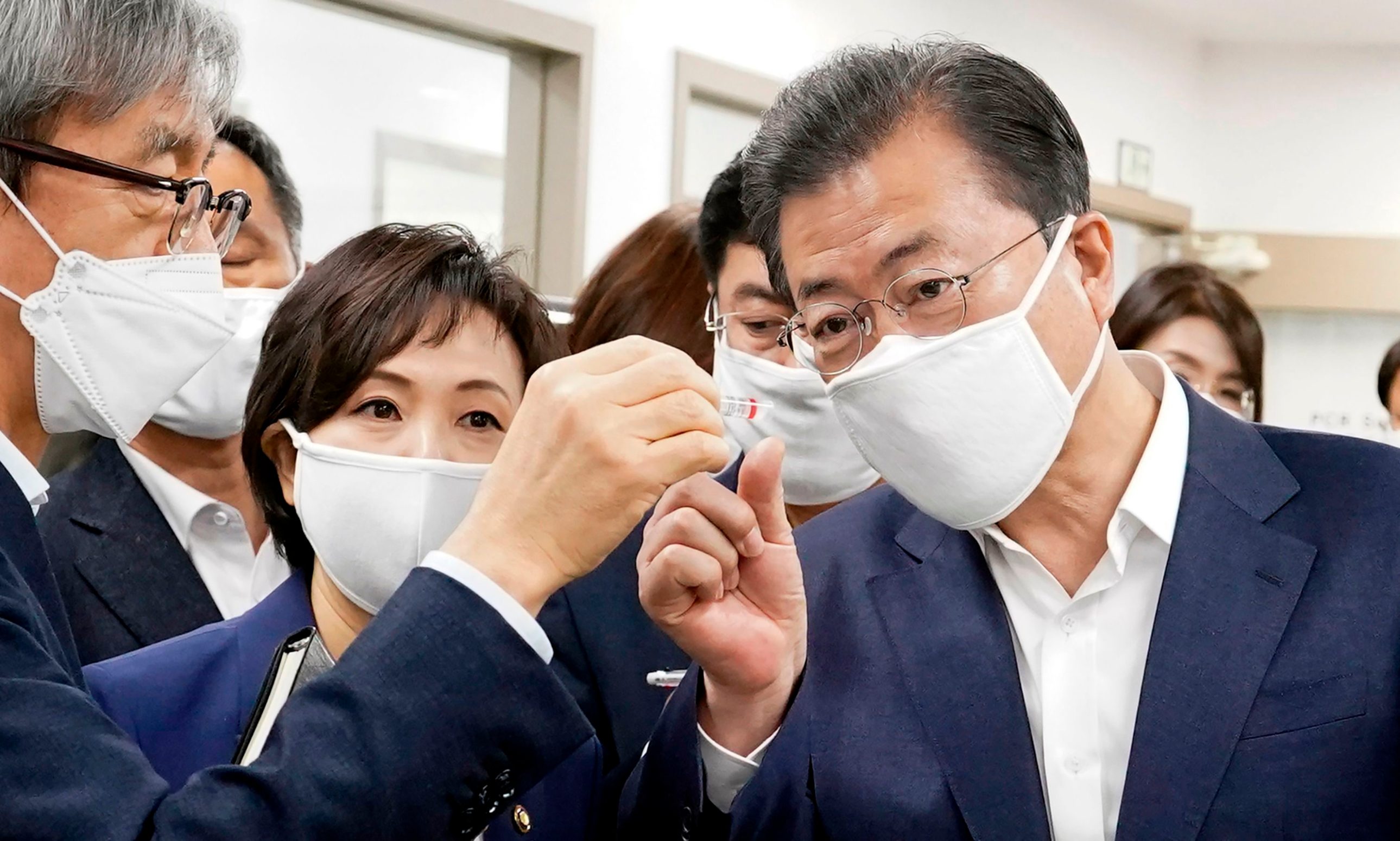 South Korean President Moon Jae-in (R) visits a Seegene research facility, a Seoul-based developer of COVID-19 diagnostic solutions, in Seoul on March 25, 2020. - At one point South Korea was the country hardest-hit by the virus outside China, but widespread testing and quarantine efforts have seen new cases fall below 100 a day. (Photo by - / YONHAP / AFP) / - South Korea OUT / REPUBLIC OF KOREA OUT  NO ARCHIVES  RESTRICTED TO SUBSCRIPTION USE