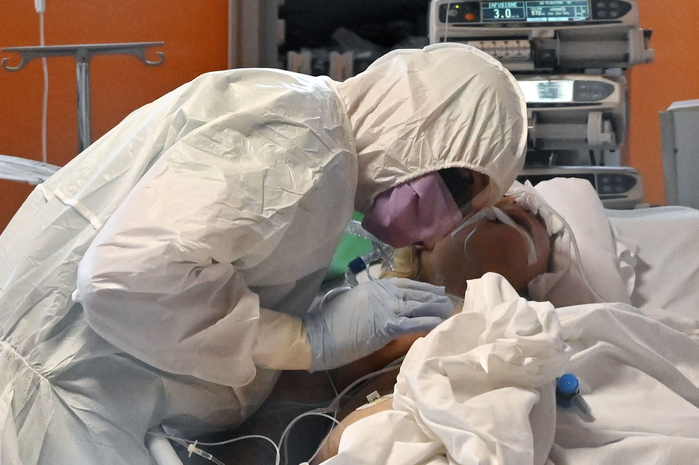 TOPSHOT - A medical worker in protective gear tends to a patient on March 24, 2020 at the new COVID 3 level intensive care unit for coronavirus COVID-19 cases at the Casal Palocco hospital near Rome, during the country's lockdown aimed at stopping the spread of the COVID-19 (new coronavirus) pandemic. (Photo by Alberto PIZZOLI / AFP)