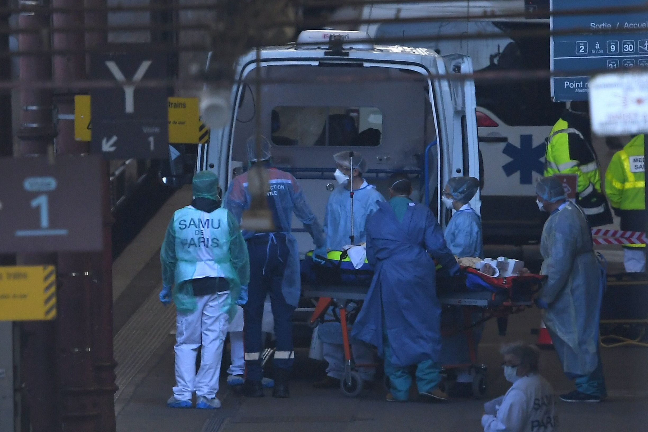 Emergency medical personnel disembark a patient from an ambulance next to a medicalised TGV (high-speed train) in Strasbourg station, eastern France, on March 26, 2020 as 20 patients affected with COVID-19 are evacuated to hospitals in the Pays-de-la-Loire region. - Preparations for the evacuation to hospitals in the Pays-de-la-Loire region of 20 coronavirus-contaminated patients from Alsace aboard a medicalised TGV - an operation unheard of in Europe - began on March 26 morning at Strasbourg station. (Photo by Patrick HERTZOG / AFP)