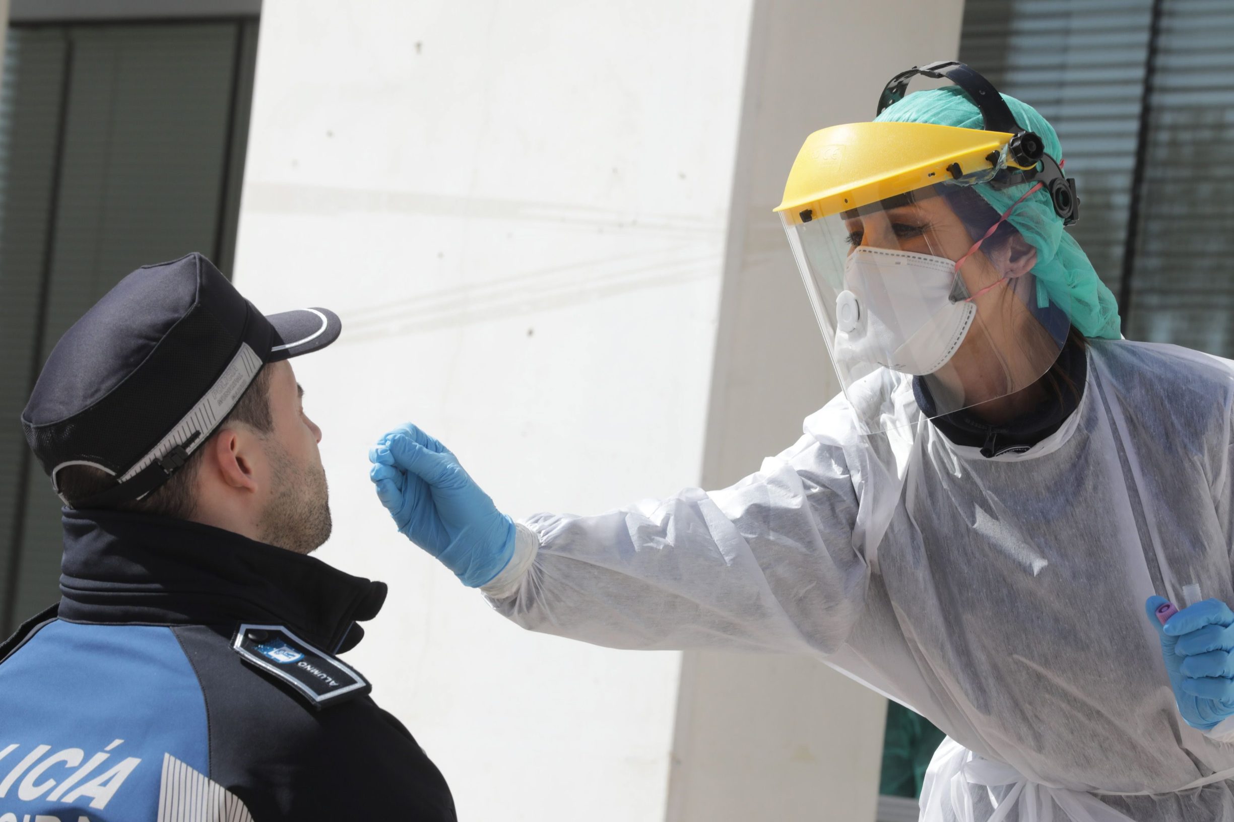 A handout picture released by the Madrid City Hall shows a health worker handling a swab to test a municipal police officer for the COVID-19 coronavirus in Madrid on March 25, 2020. - Spain's coronavirus death toll overtook that of China, rising to 3,434 after another 738 people died as Madrid announced a multi-million-euro deal with Beijing for critical supplies. (Photo by Rafa ALBARRAN / Madrid City Hall / AFP) / RESTRICTED TO EDITORIAL USE - MANDATORY CREDIT 