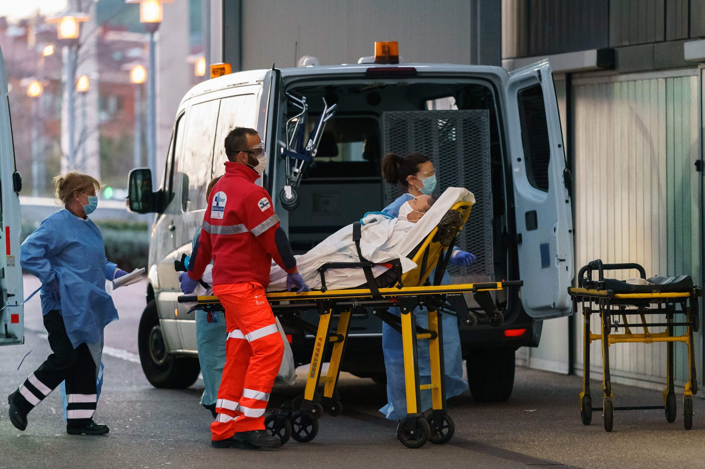 Paramedics wheel a patient into the Burgos general hospital in Burgos on March 25, 2020. - As the global death toll soared past 20,000, Spain joined Italy in seeing its number of fatalities overtake China, where the virus first emerged just three three months ago. (Photo by CESAR MANSO / AFP)