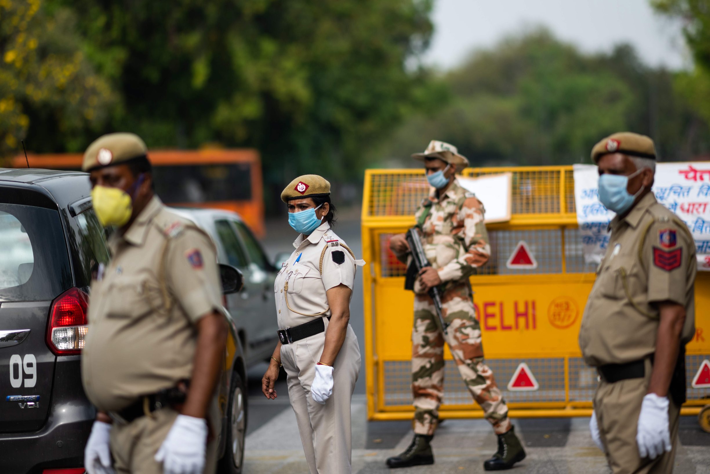Security personnel stand guard at a checkpoint during a government-imposed nationwide lockdown as a preventive measure against the COVID-19 coronavirus in New Delhi on March 26, 2020. (Photo by Jewel SAMAD / AFP)