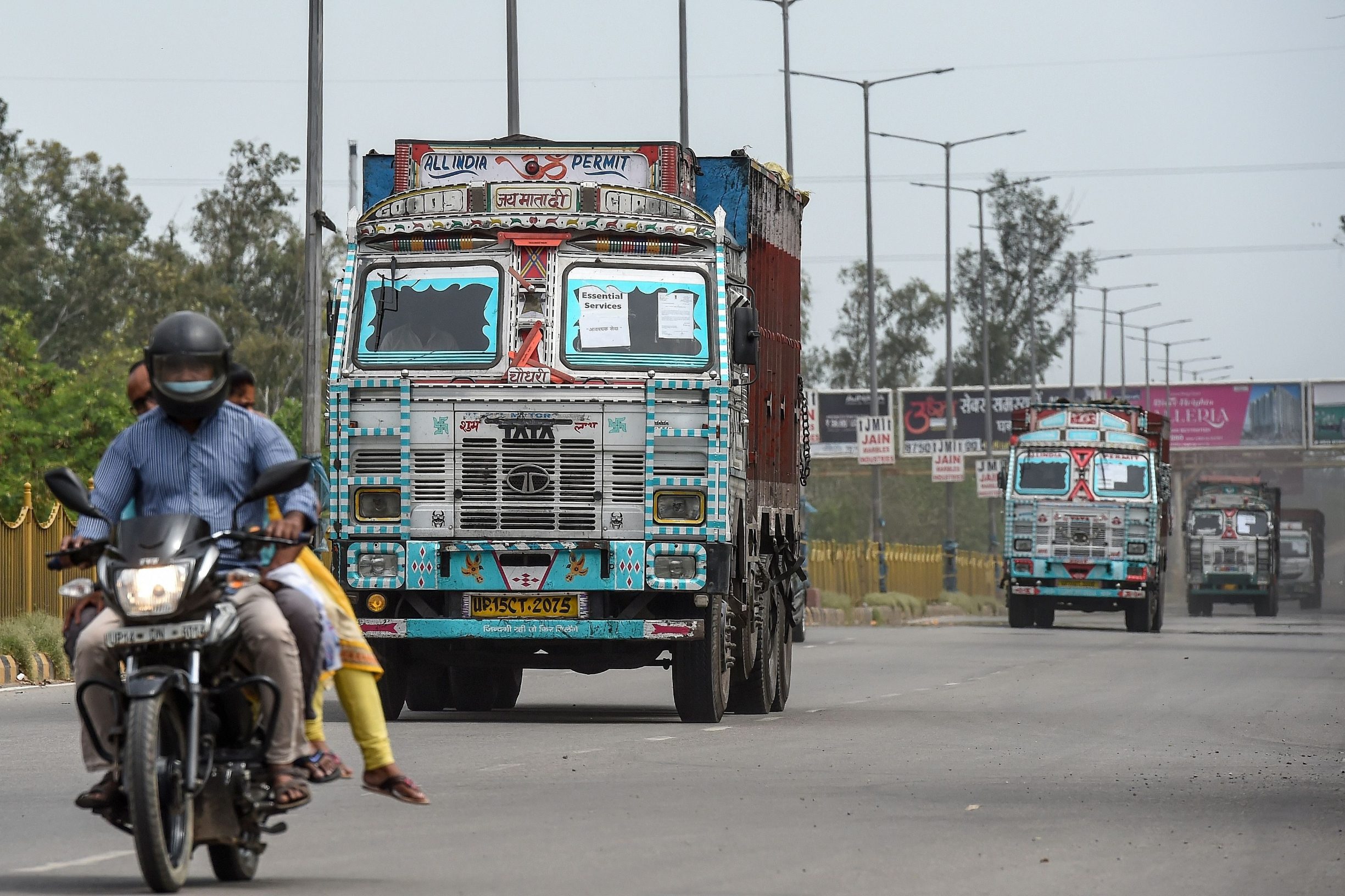 Trucks carrying food and essential commodities drive on a national highway during a government-imposed nationwide lockdown as a preventive measure against the COVID-19 coronavirus in Ghaziabad in Uttar Pradesh state on March 26, 2020. (Photo by Prakash SINGH / AFP)