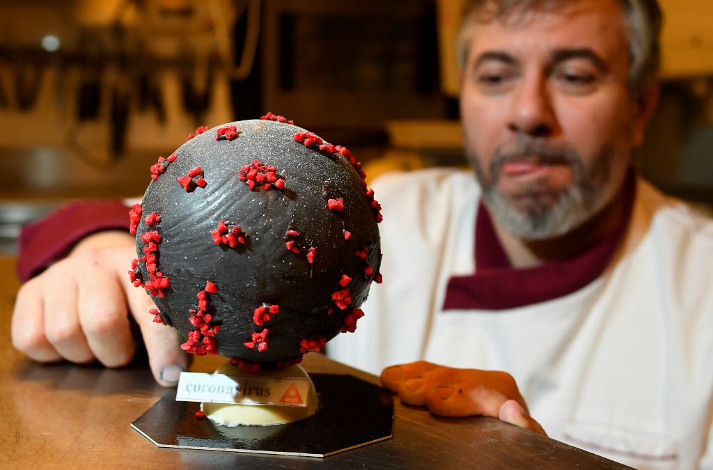 Chocolate maker Jean-Fran�ois Pre shows an easter egg shaped like a novel Coronavirus, the cause of the COVID-19 outbreak, made of white chocolate coloured in black and red coloured almonds, in his shop in Landivisiau, western France, on March 7, 2020. (Photo by Damien MEYER / AFP)
