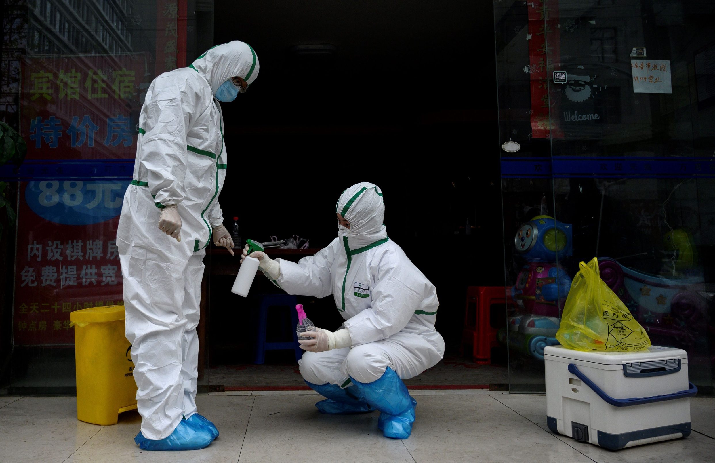 A medical worker wearing a hazmat suit disinfects a colleague at a testing clinic for COVID-19 novel coronavirus in Wuhan, in China's central Hubei province on March 29, 2020. (Photo by NOEL CELIS / AFP)