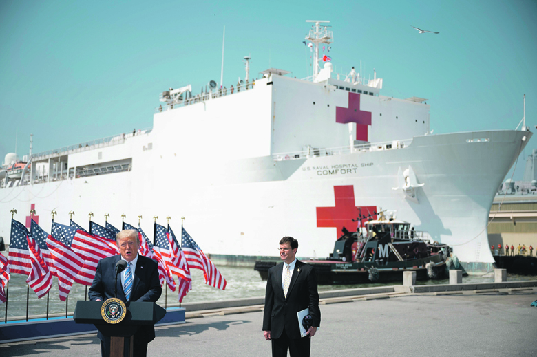 US President Donald Trump, with Defense Secretary Mark Esper, speaks during the departure ceremony for the hospital ship USNS Comfort at Naval Base Norfolk on March 28, 2020, in Norfolk, Virginia. - The Comfort sails to New York City to aid in the coronavirus outbreak. (Photo by JIM WATSON / AFP)