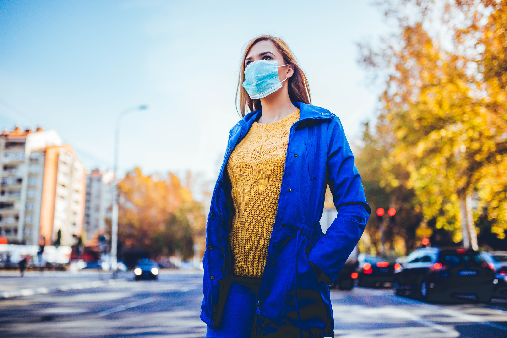 Young woman wearing face mask because of air pollution in the city