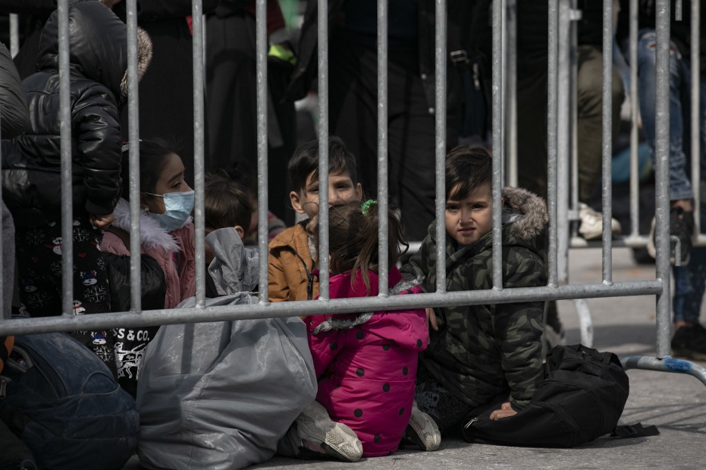 LESBOS, GREECE - MARCH 04: Asylum seekers wait to get on board to a military ship, which docked at a harbour to take asylum seekers to the main land from the harbour, in Lesbos, Greece on March 04, 2020. Anadolu Agency reporters were not allowed on the board on the contrary other journalists. Aggelos Barai / Anadolu Agency