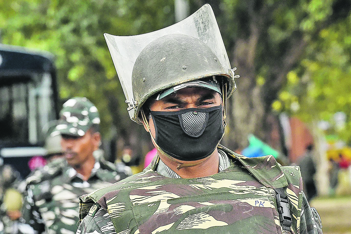 A security personnel wears a facemask as he accompanies a peace march on a road in New Delhi on March 6, 2020. - The number of novel coronavirus cases in the world rose to 98,123, including 3,385 deaths, across 87 countries and territories by 0900 GMT on March 6, according to a report compiled by AFP from official sources. (Photo by Prakash SINGH / AFP)
