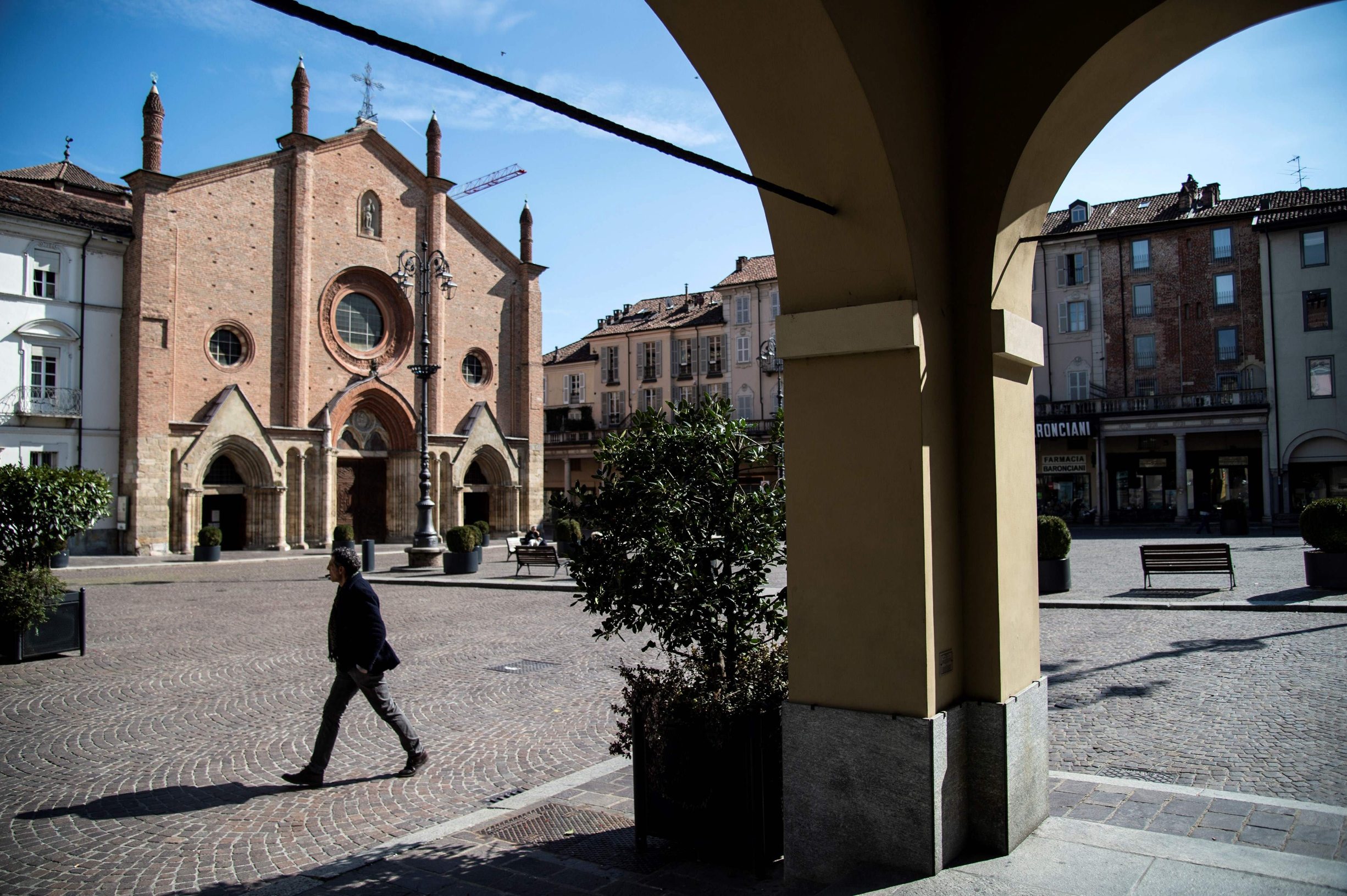 A man walks in Piazza San Secondo on March 8, 2020 in Asti, a new quarantine zone in Northwestern Italy. - A quarter of the Italian population was locked down on March 8, 2020 as the government takes drastic steps to stop the spread of the deadly new coronavirus that is sweeping the globe, with Latin America recording its first fatality. (Photo by MARCO BERTORELLO / AFP)
