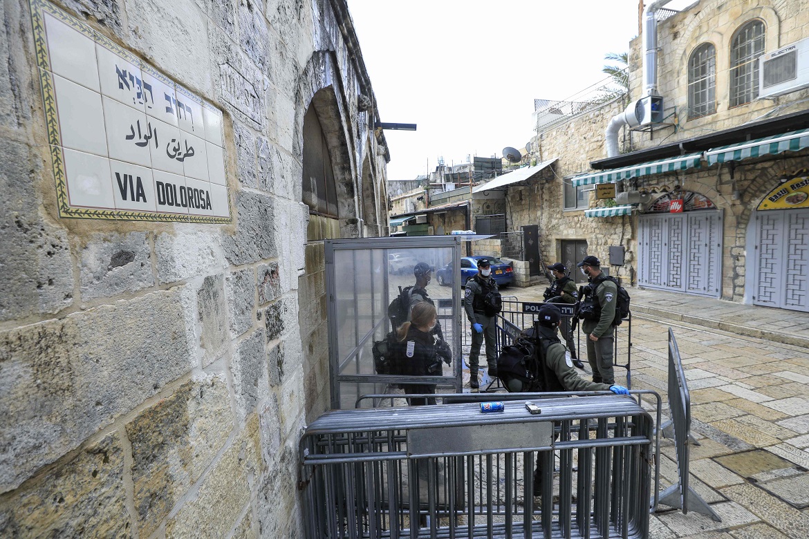 Members of Israeli police wearing protective masks stand guard on a deserted Via Dolorosa, a route usually packed with worshippers in procession to mark Good Friday, now empty amid the COVID-19 pandemic crisis, in Jerusalem's Old City on April 10, 2020. - All cultural sites in the Holy Land are shuttered, regardless of their religious affiliation, as authorities seek to forestall the spread of the deadly respiratory disease, which will prevent Christians from congregating for the Easter service, this coming Sunday for Catholic worshippers, then a week later on April 19 for Orthodox Easter. (Photo by EMMANUEL DUNAND / AFP)