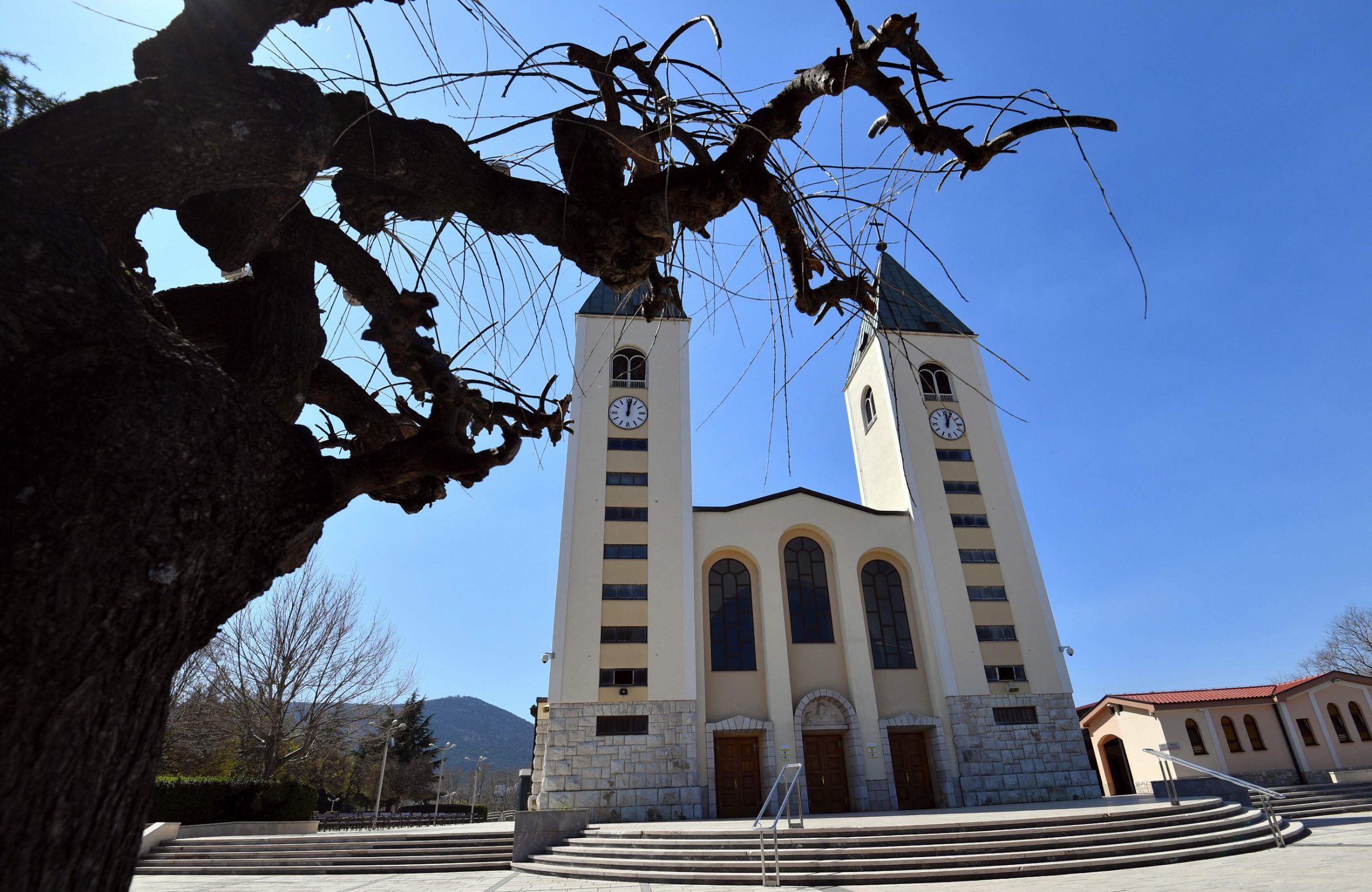 General view of the empty main square in front of St Jacob church, usually riddled with thousands of Catholic believers, at Marian pilgrimage site, in the southern Bosnian town of Medjugorje, on April 7, 2020 during a lockdown to stop the spread of COVID-19 (novel coronavirus). - Ever since the Virgin Mary was said to appear before six teenagers on a hill in Bosnia four decades ago, pilgrims have flocked to the town of Medjugorje, eager to witness a miracle. (Photo by ELVIS BARUKCIC / AFP)