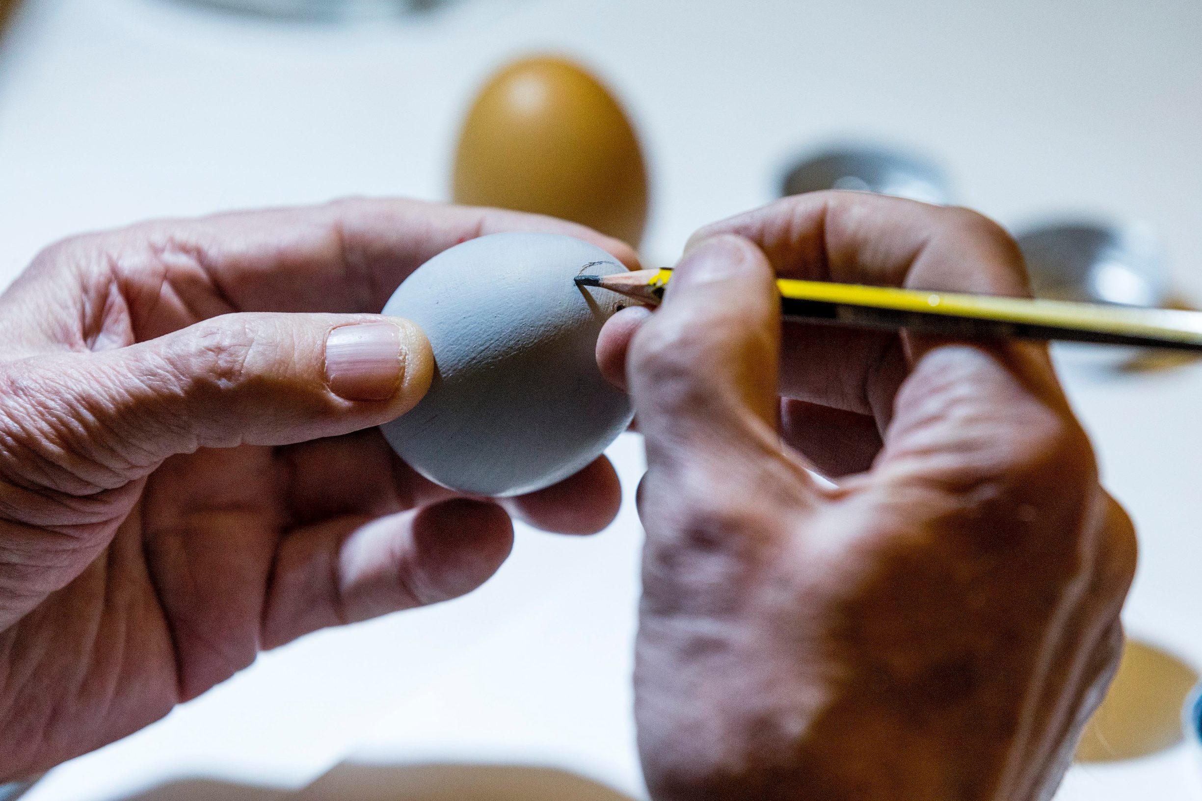 Zagreb, 070420.
Jurisiceva.
Umirovljeni animator Tomislav Sporis pokazuje kako oslikava svoja uskrsnja jaja.
Na fotografiji: bojanje temeljnom bojom i pocetak skiciranja.
Foto: Tomislav Kristo / CROPIX