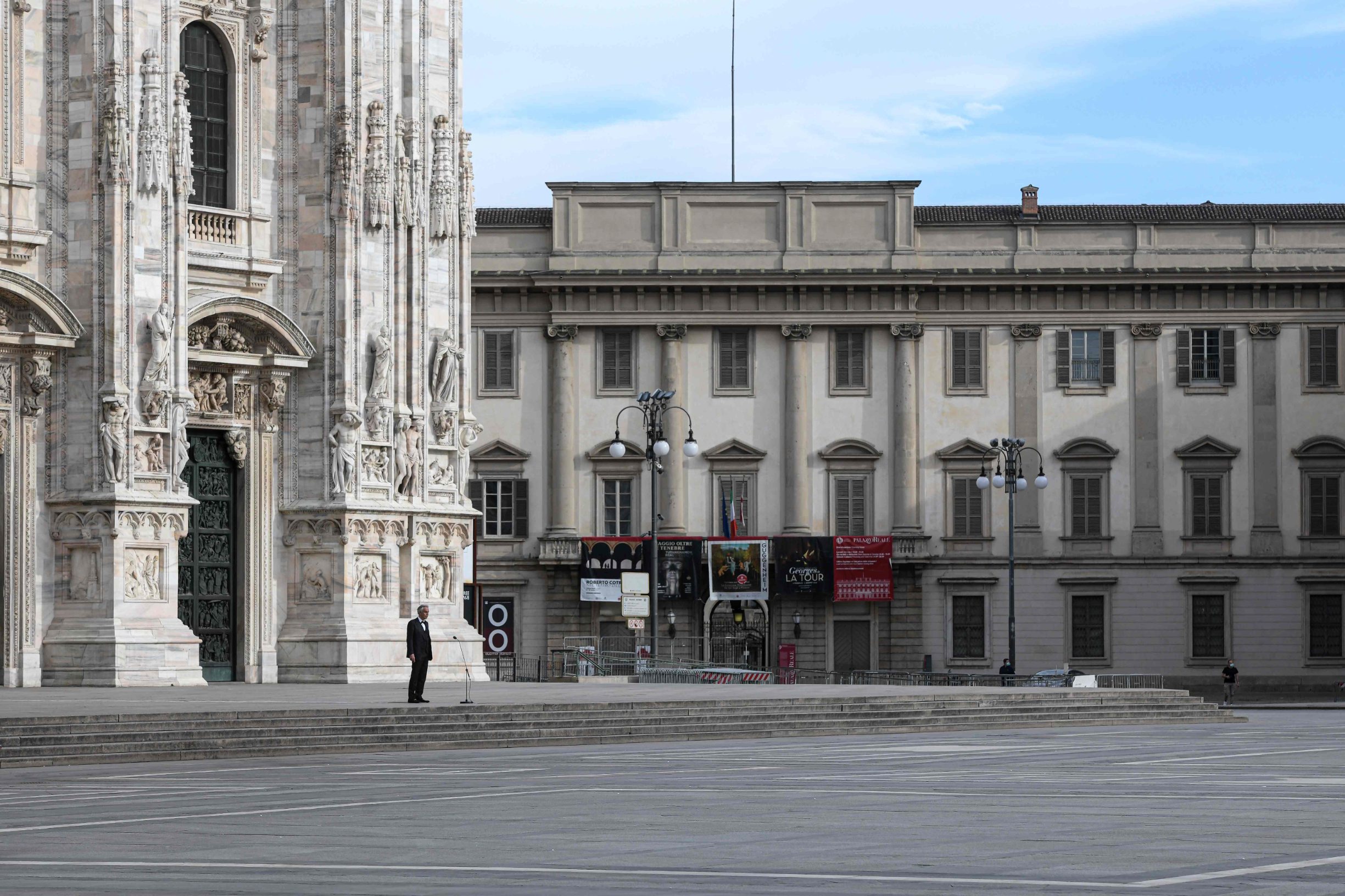 Italian tenor and opera singer Andrea Bocelli (L) rehearses on a deserted Piazza del Duomo in central Milan on April 12, 2020, prior to an evening performance without public for the world wounded by the pandemic, during the country's lockdown aimed at curbing the spread of the COVID-19 infection, caused by the novel coronavirus. (Photo by Piero Cruciatti / AFP)