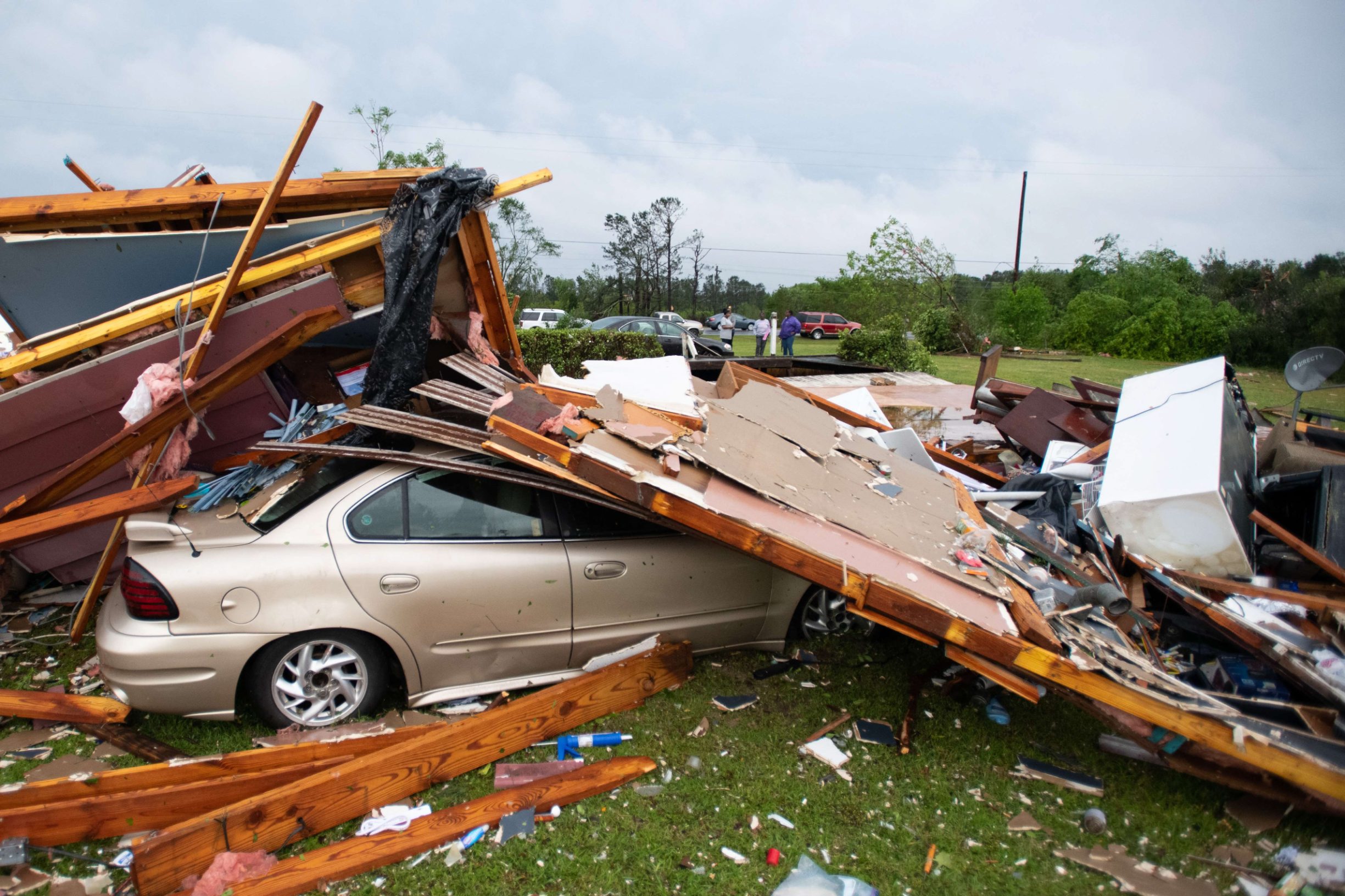 LIVINGSTON, SC - APRIL 13: Pieces of a storm damaged home home partially cover a car April 13, 2020 in Livingston, South Carolina. A string of storms caused more than a dozen deaths across the southern United States.   Sean Rayford/Getty Images/AFP
== FOR NEWSPAPERS, INTERNET, TELCOS & TELEVISION USE ONLY ==