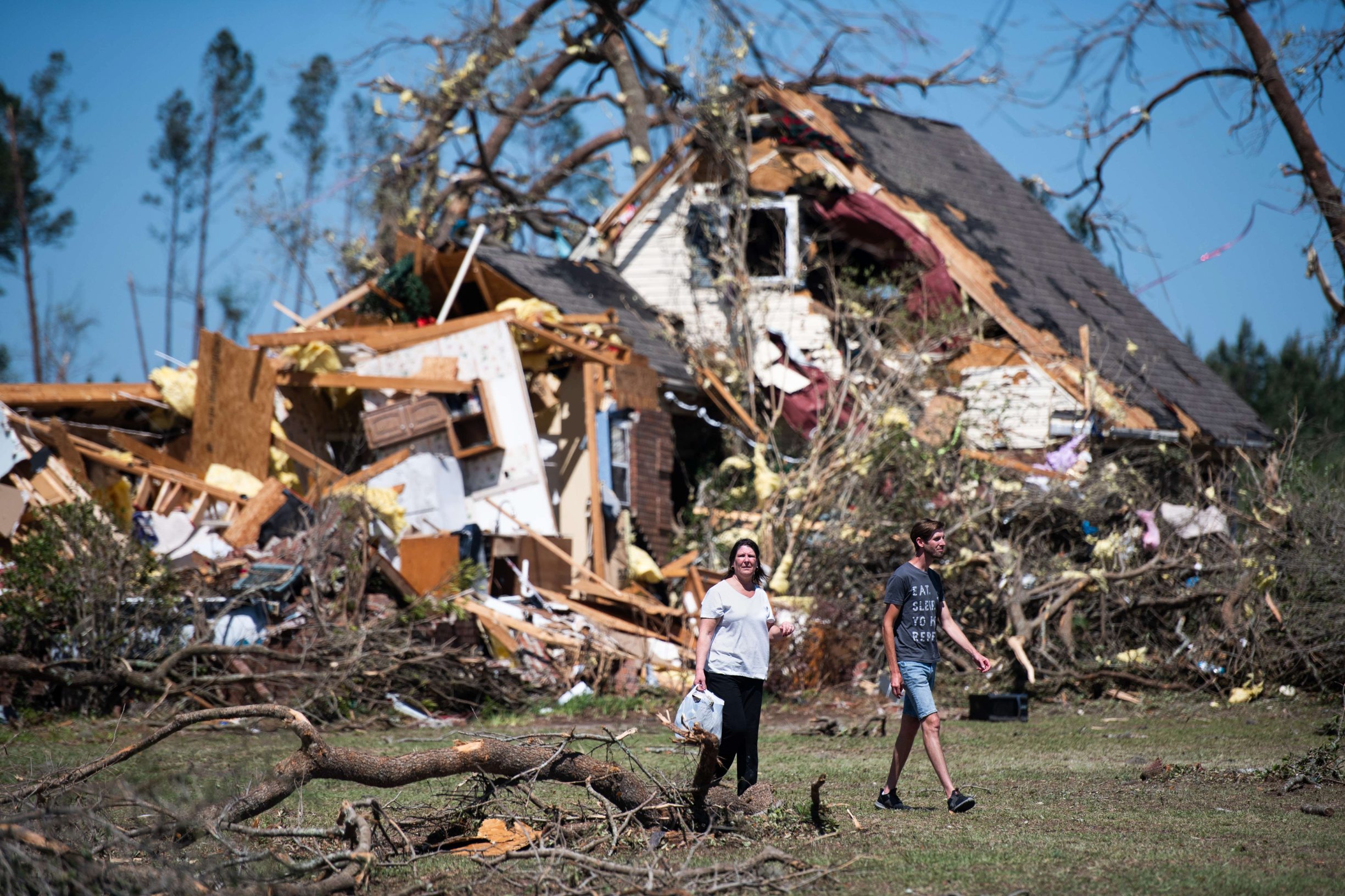 NIXVILLE, SC - APRIL 13: People walk in front of a home destroyed by a tornado on April 13, 2020 near Nixville, South Carolina. A string of storms across the southern United States that began Easter Sunday and continued into today produced multiple tornados resulting in more than 30 deaths and dozens more injuries.   Sean Rayford/Getty Images/AFP
== FOR NEWSPAPERS, INTERNET, TELCOS & TELEVISION USE ONLY ==