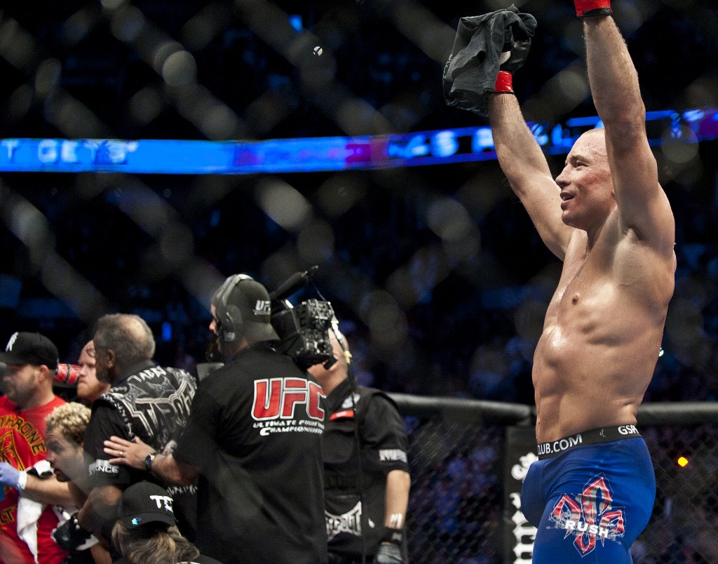 Georges St-Pierre (R) from Montreal, Canada celebrates victory over Josh Koscheck from Waynesburg US after the end of the fifth round of the Ultimate Fighting Championship on December 11, 2010 at Bell Centre in Montreal, Quebec, Canada.    AFP PHOTO / ROGERIO BARBOSA (Photo by ROGERIO BARBOSA / AFP)