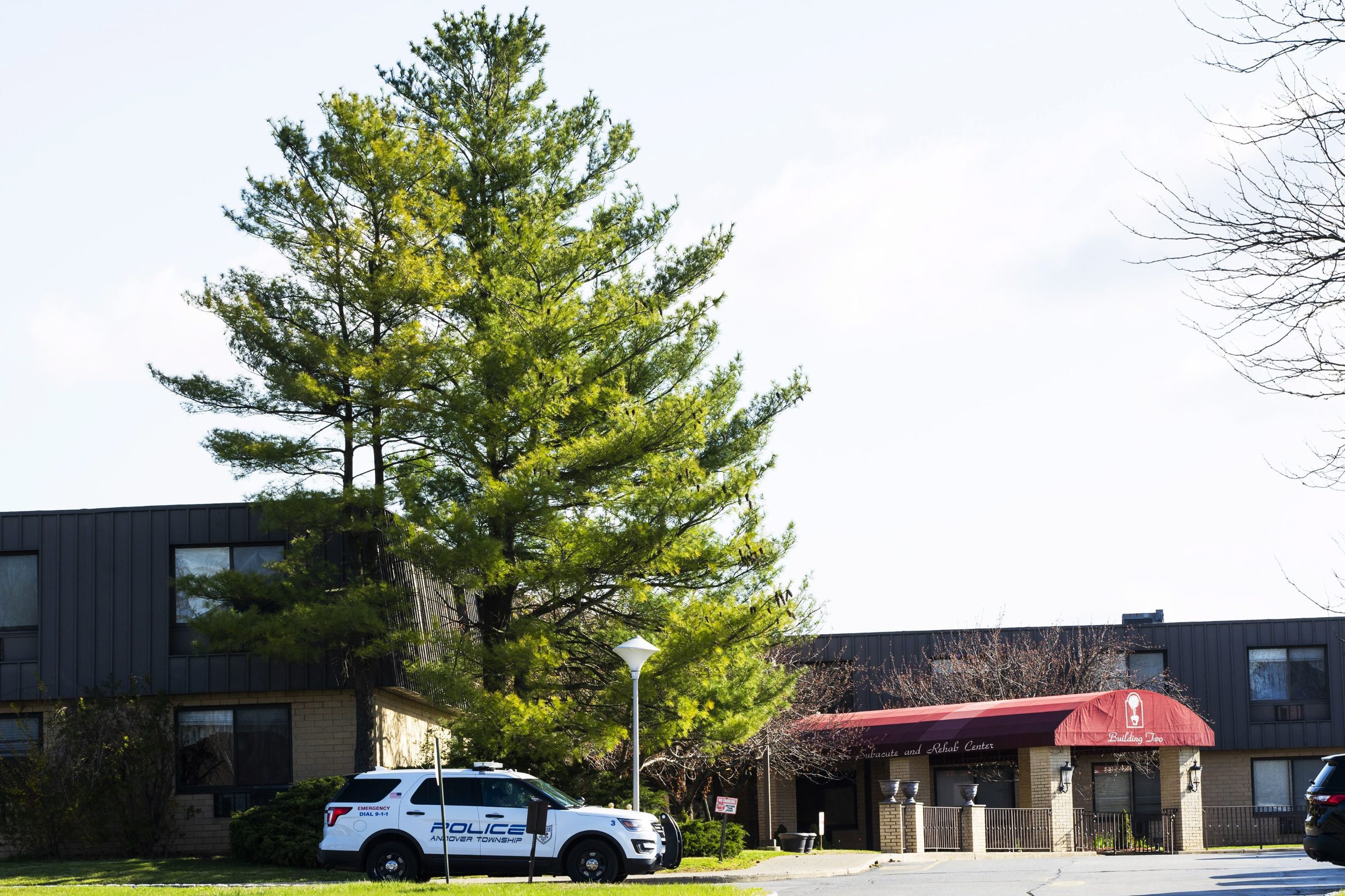 ANDOVER, NJ - APRIL 16: A New Jersey Police vehicle parks at the entrance of Andover Subacute and Rehabilitation Center on April 16, 2020 in Andover, New Jersey. After an anonymous tip to police, 17 people were found dead at the long-term care facility, including two nurses, where at least 76 patients and 41 staff members have tested positive for COVID-19.   Eduardo Munoz Alvarez/Getty Images/AFP
== FOR NEWSPAPERS, INTERNET, TELCOS & TELEVISION USE ONLY ==