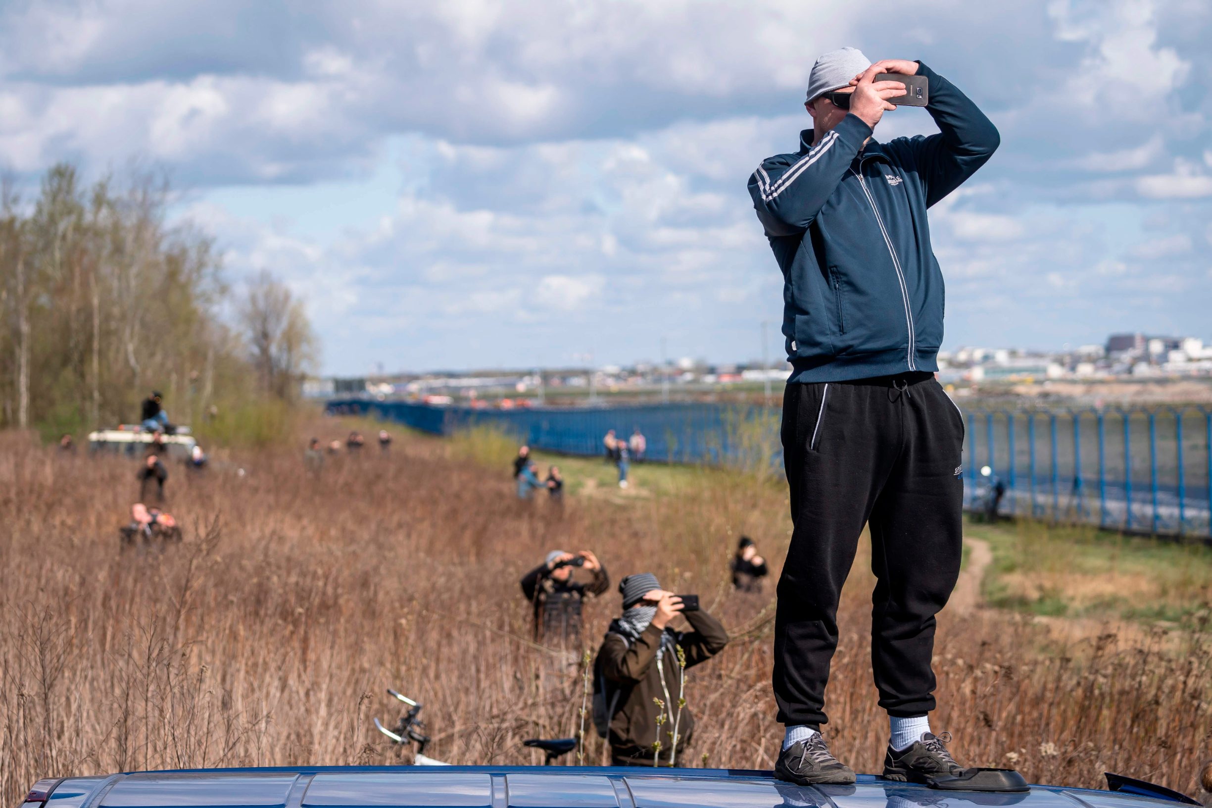 People watch an Ukrainian Antonov-225 Mriya aircraft landing at the International Warsaw Chopin Airport on April 14, 2020 as it arrives from China loaded with medical equipment needed against the novel coronavirus. (Photo by Wojtek RADWANSKI / AFP)