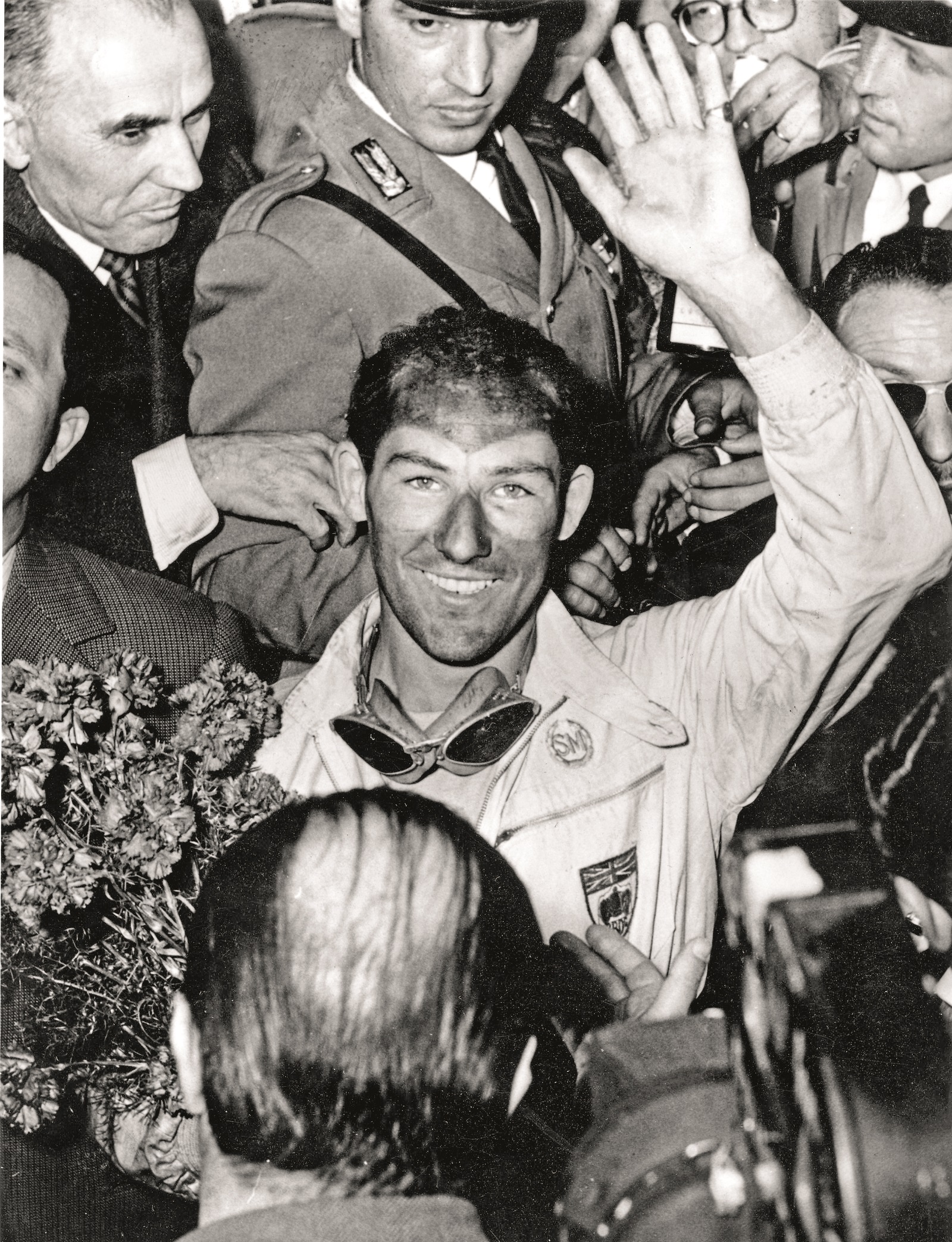 British racing driver Stirling Moss waves for the cameras after winning the Italian Mille Miglia Race, setting a new record.   (Photo by Keystone/Getty Images)