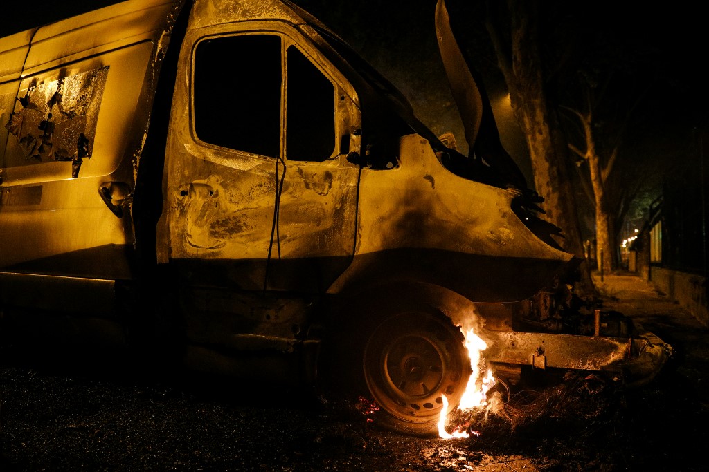 The wheel of a van burns in Villeneuve-la-Garenne, in the northern suburbs of Paris, early on April 20, 2020. - Tension with the police erupted again on the evening of April 19 in Villeneuve-la-Garenne near Paris, where a motorcycle accident involving the police had provoked the first clashes with residents the day before. (Photo by GEOFFROY VAN DER HASSELT / AFP)