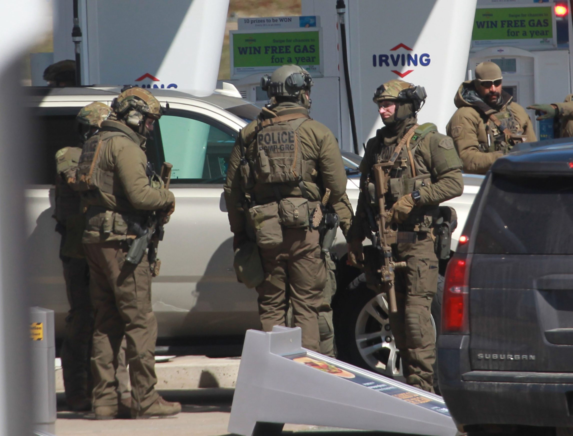 Members of the Royal Canadian Mounted Police (RCMP) tactical unit confer after the suspect in a deadly shooting rampage was neutralized at the Big Stop near Elmsdale, Nova Scotia, Canada, on April 19, 2020. - A gunman killed at least 10 people in an overnight shooting rampage across rural Nova Scotia, before being found dead following an hours-long manhunt, Canadian federal police said April 19. Earlier identified as 51-year-old Gabriel Wortman, the suspect had been on the run since Saturday night, when police were alerted to shots being fired in the small community of Portapique, around 100 kilometers (60 miles) from Halifax, capital of the Atlantic province. (Photo by tim krochak / AFP)