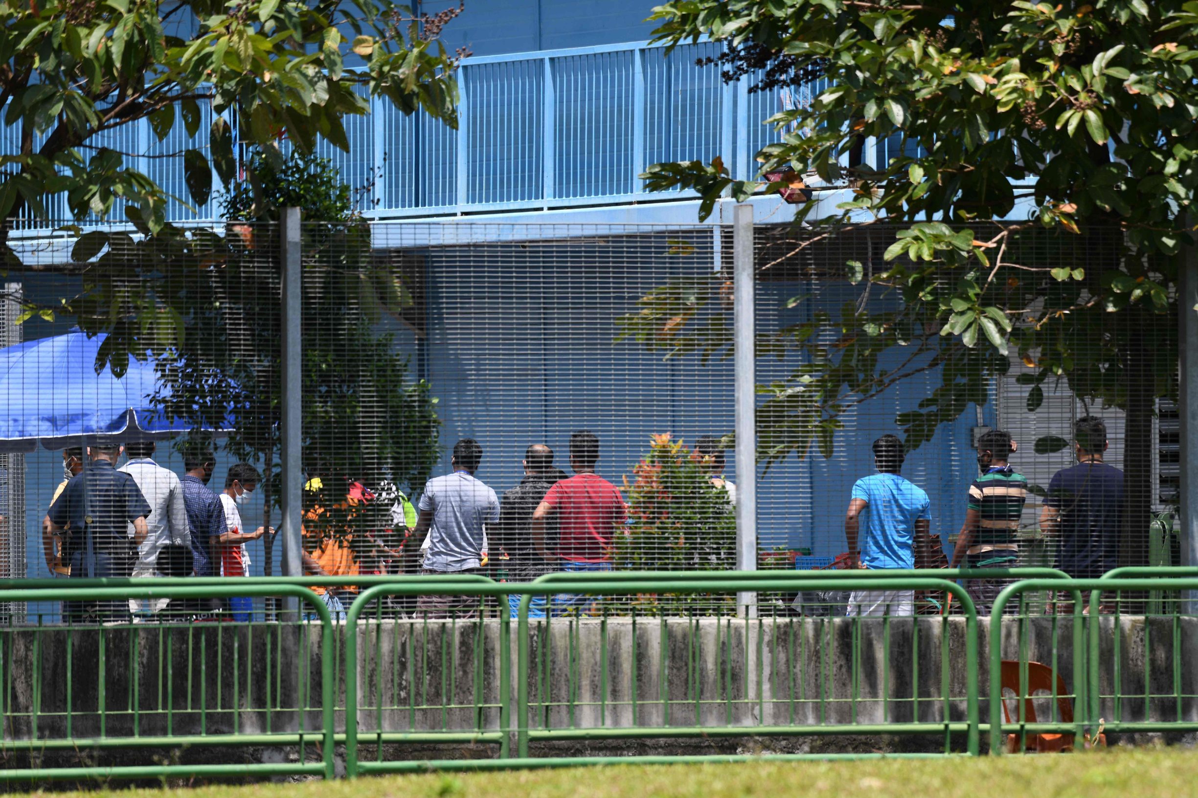 Residents queue for their food at Tuas South foreign workers dormitory that has been placed under government restriction as preventive measure against the spread of the COVID-19 coronavirus in Singapore on April 19, 2020. - Singapore imposed a mandatory stay-home order for migrant workers including in the construction sector for 14 days effective on April 20 due to coronavirus pandemic. (Photo by Roslan RAHMAN / AFP)