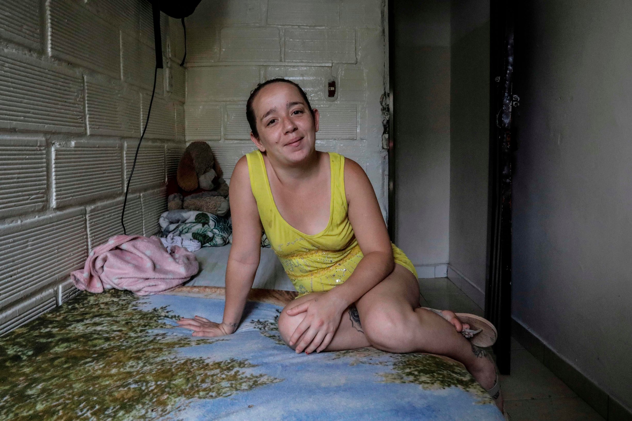 Sex worker Estefania poses for a picture in her bedroom at a low cost hotel located in the Tolerance zone known as the Raudal Sector, where sex workers live and work in Medellin, Colombia, on April 8, 2020. (Photo by Joaquin SARMIENTO / AFP)