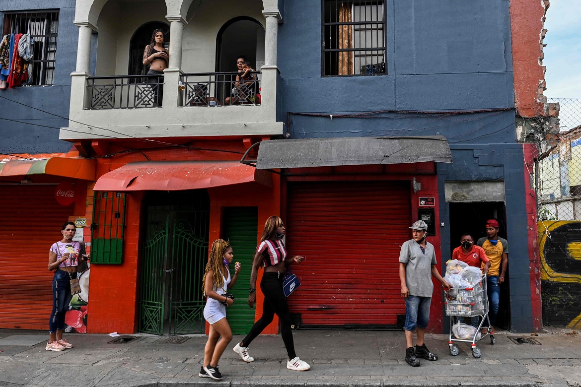 People are seen outside a low cost hotel located in the Tolerance zone known as the Raudal Sector, where sex workers live and work in Medellin, Colombia, on April 6, 2020. (Photo by Joaquin SARMIENTO / AFP)