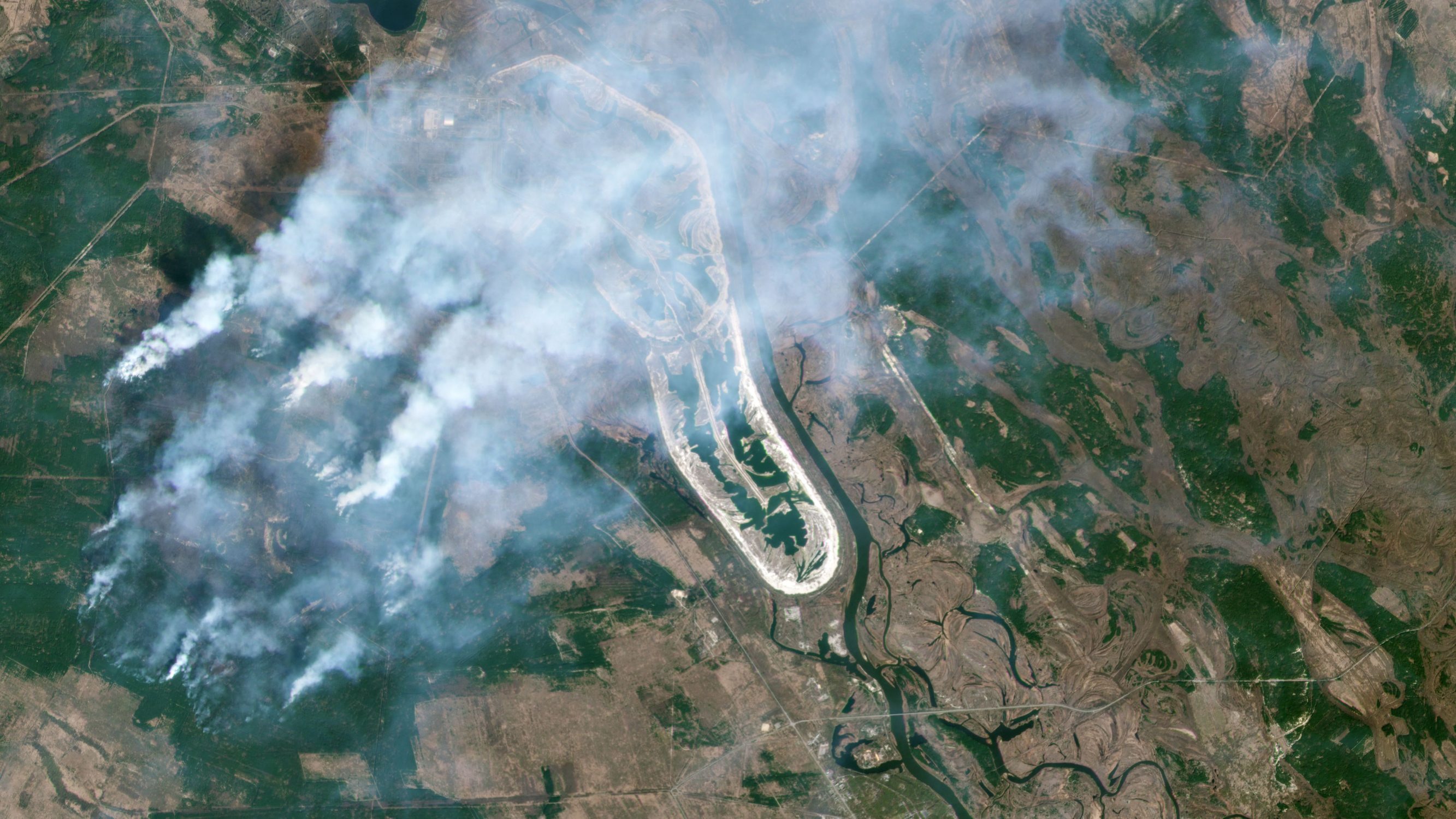 TOPSHOT - This handout satellite image taken on April 9, 2020 and released on April 15, 2020 by 2020 Planet Labs shows a forest fire burning in the Chernobyl exclusion zone in Ukraine, not far from the nuclear power plant. - Ukraine said on April 14 only small fires remained in the Chernobyl exclusion zone, with rain coming to the rescue in the battle against a huge blaze. The fire broke out 10 days ago at the scene of the world's worst nuclear accident in 1986 and on April 13 had reached just 1.5 kilometers from the protective dome over the ruined reactor, Greenpeace Russia said. (Photo by - / Planet Labs Inc. / AFP) / RESTRICTED TO EDITORIAL USE - MANDATORY CREDIT 