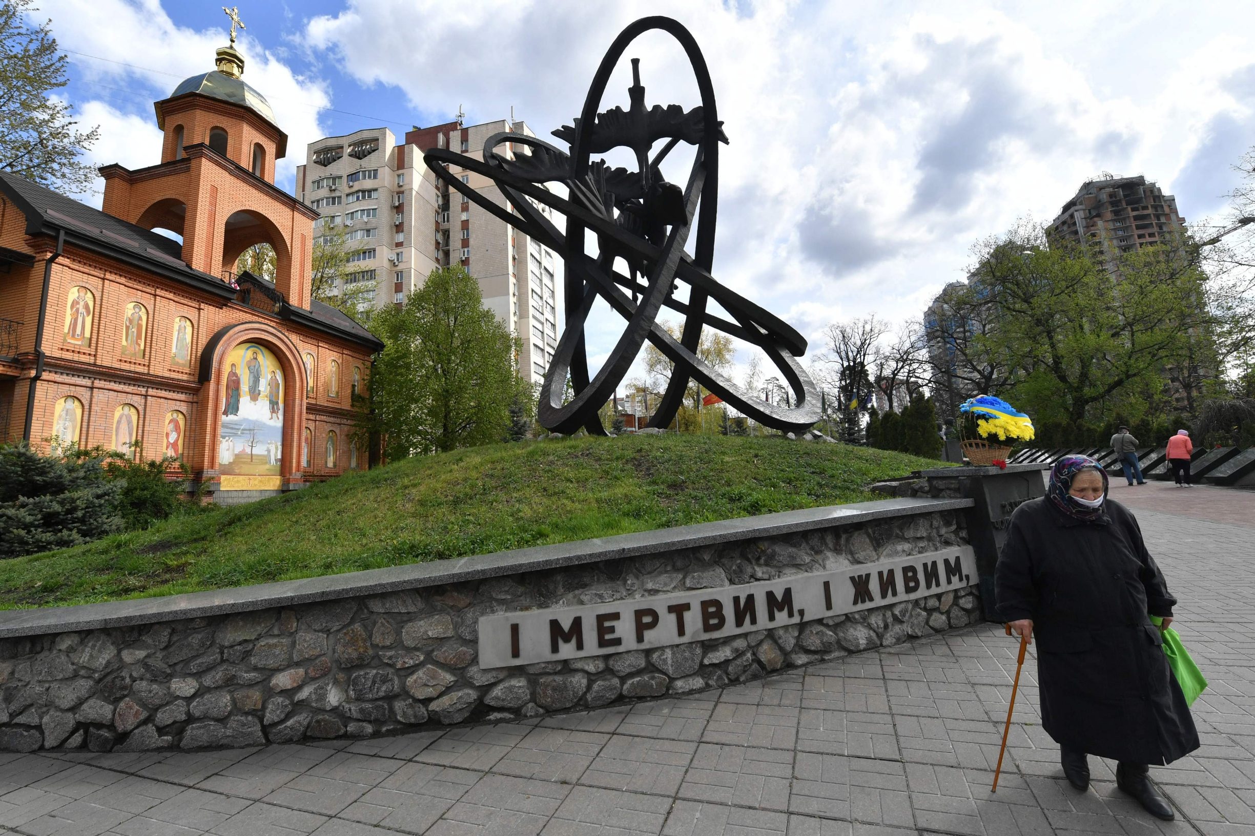 An elderly woman wearing a face mask visits Chernobyl's memorial in Kiev to commemorate the victims on the 34th anniversary of the tragedy on April 26, 2020, amid the COVID-19 coronavirus pandemic. - Ukraine on April 26, 2020 marks the 34th anniversary of the Chernobyl disaster which was the world's worst nuclear accident. (Photo by Sergei SUPINSKY / AFP)