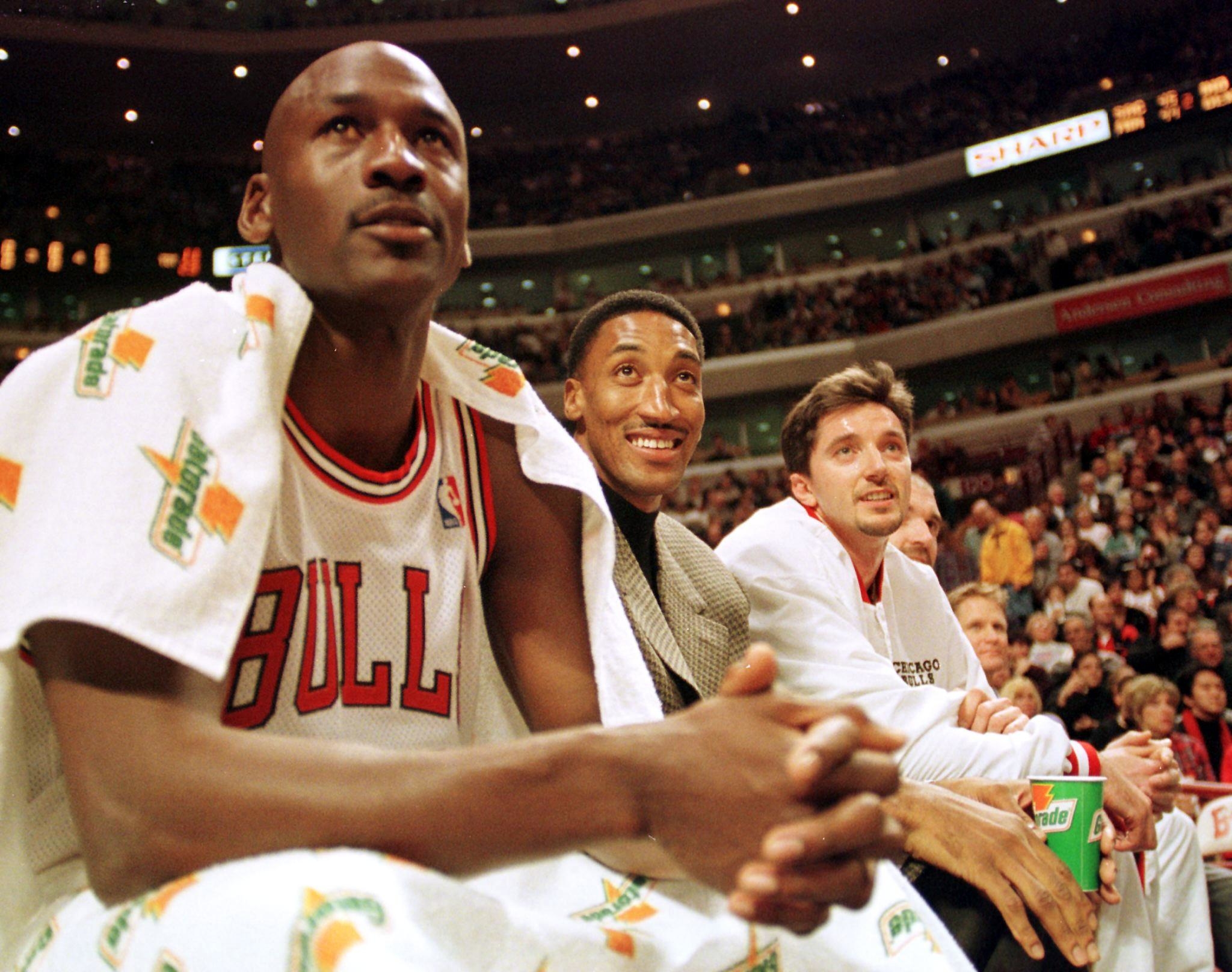 Chicago Bulls guard Michael Jordan (L), injured forward Scottie Pippen (C) and forward Toni Kukoc watch their teammates play against the Milwaukee Bucks during the second quarter 05 December at the United Center, in Chicago, IL.  Pippen has demanded that he be traded to another team following his recovery from foot surgery.  AFP PHOTO/VINCENT LAFORET (Photo by VINCENT LAFORET / AFP)