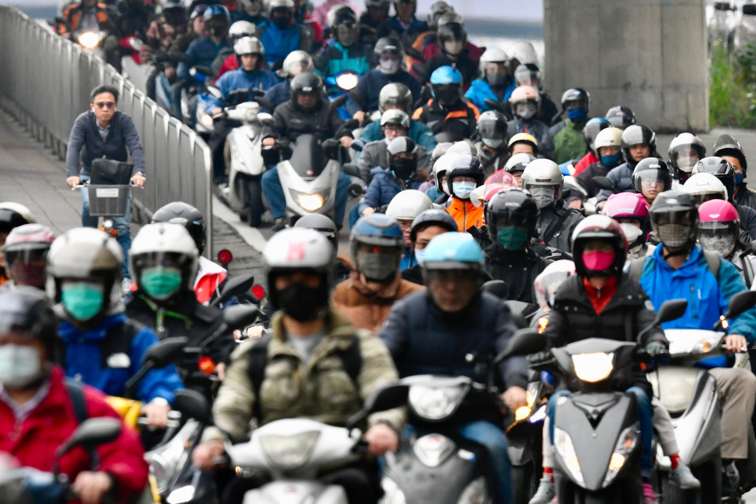 Motorcyclists wearing face masks to prevent the COVID-19 coronavirus, ride during the peak hours while heading to work in Taipei on March 18, 2020. (Photo by Sam Yeh / AFP)