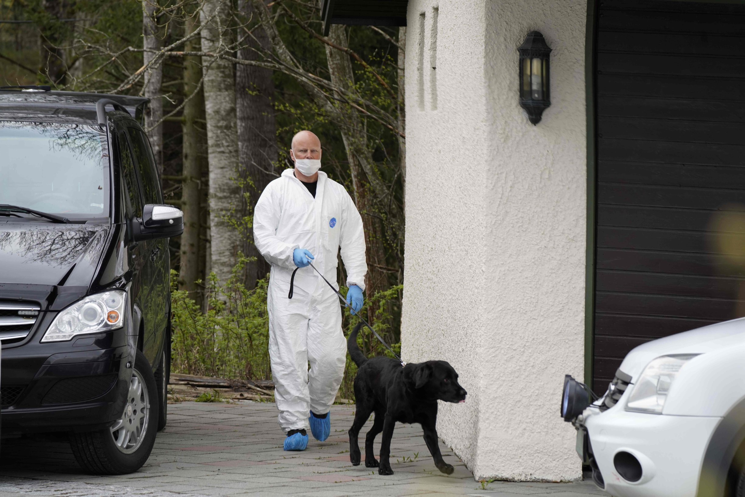 A Policeman with a dog searches the residence of the Hagen couple in Lorenskog near Oslo, Norway after Anne-Elisabeth Hagen's husband, Tom Hagen, was arrested in a police action in Lorenskog on April 28, 2020. - Norwegian police said on April 28, 2020 they had arrested wealthy businessman Tom Hagen over the disappearance of his wife 18 months ago, the latest twist in a case that has kept the Nordic countries on tenterhooks. Tom Hagen, 70, was arrested as he was leaving his home for work, on suspicion of 