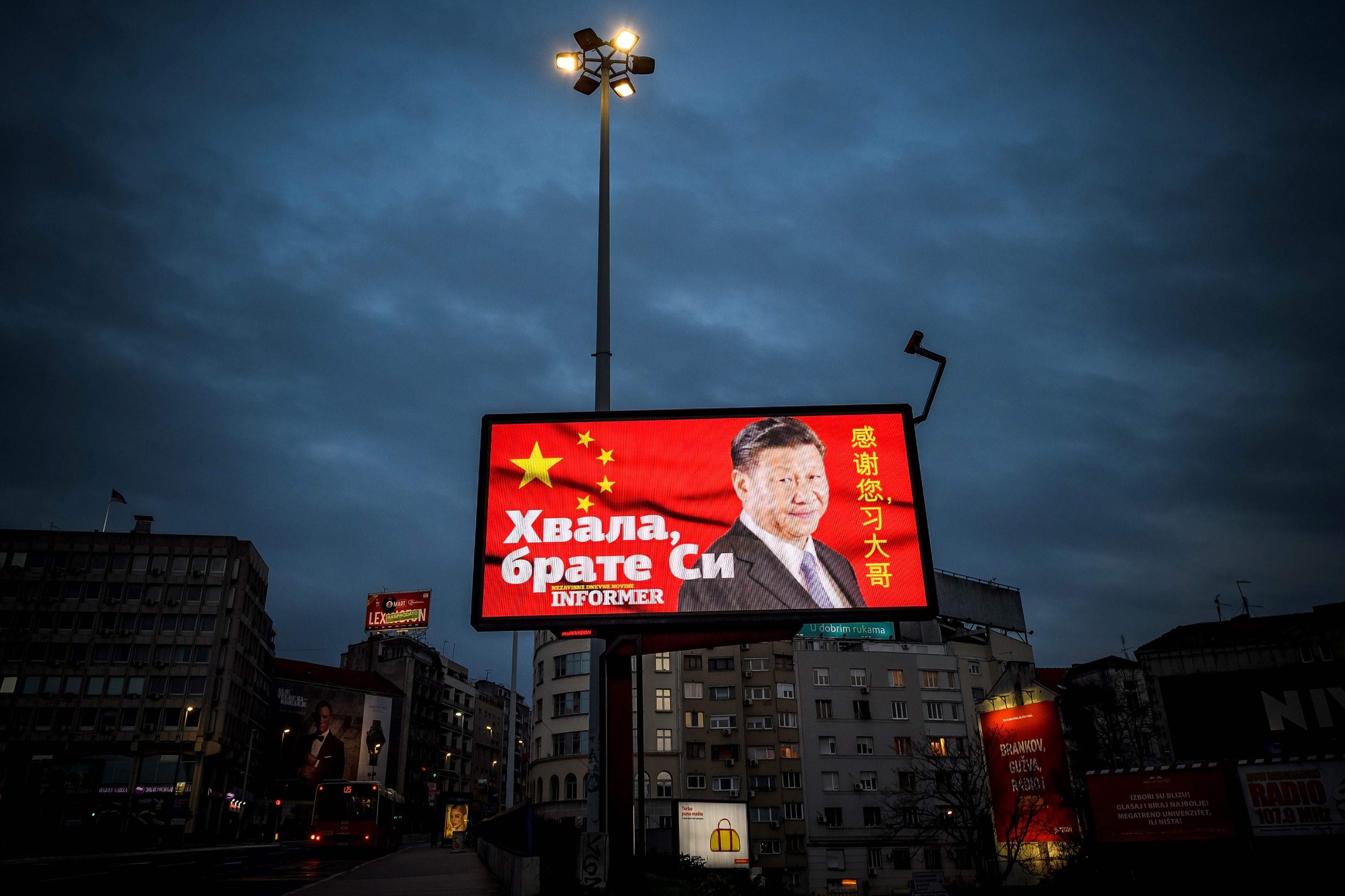 A picture taken on March 30, 2020, shows a billboard bearing Chinese President Xi Jinping's face looking down over a boulevard next to the words 