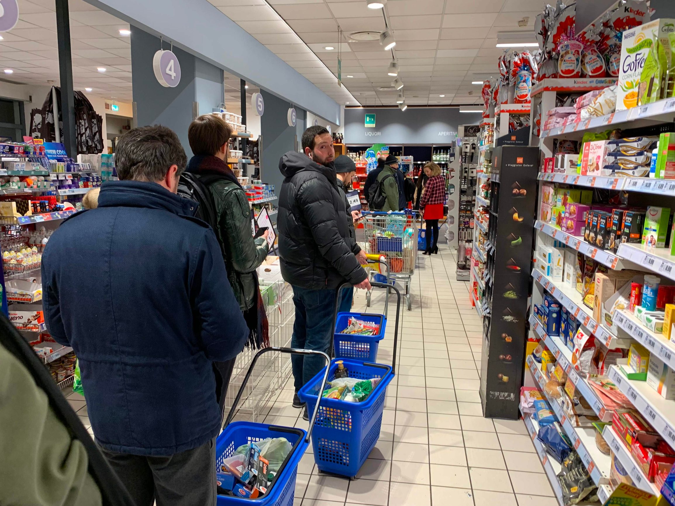 (FILES) In this file photo taken on March 07, 2020 Customers queue to pay their food and essential products in a supermarket of Milan centre on late March 7, 2020 after Italy prepared to quarantine more than 10 million people around the financial capital Milan and the tourist mecca Venice for nearly a month to halt the spread of the new coronavirus. - Around the world, where millions of people are quarantined at home, people can still shop for food at grocery stores, heightening risk for the sector's employees. (Photo by Miguel MEDINA / AFP)