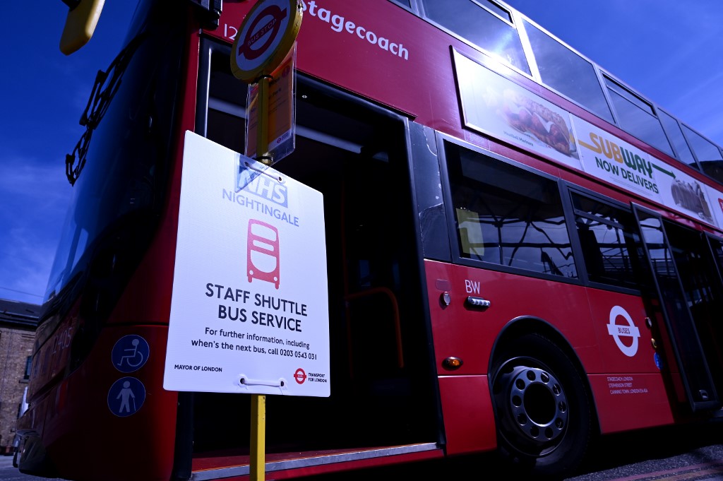 A bus is parked at a staff shuttle bus stop on the perimeter at the ExCeL London exhibition centre, which has been transformed into the 